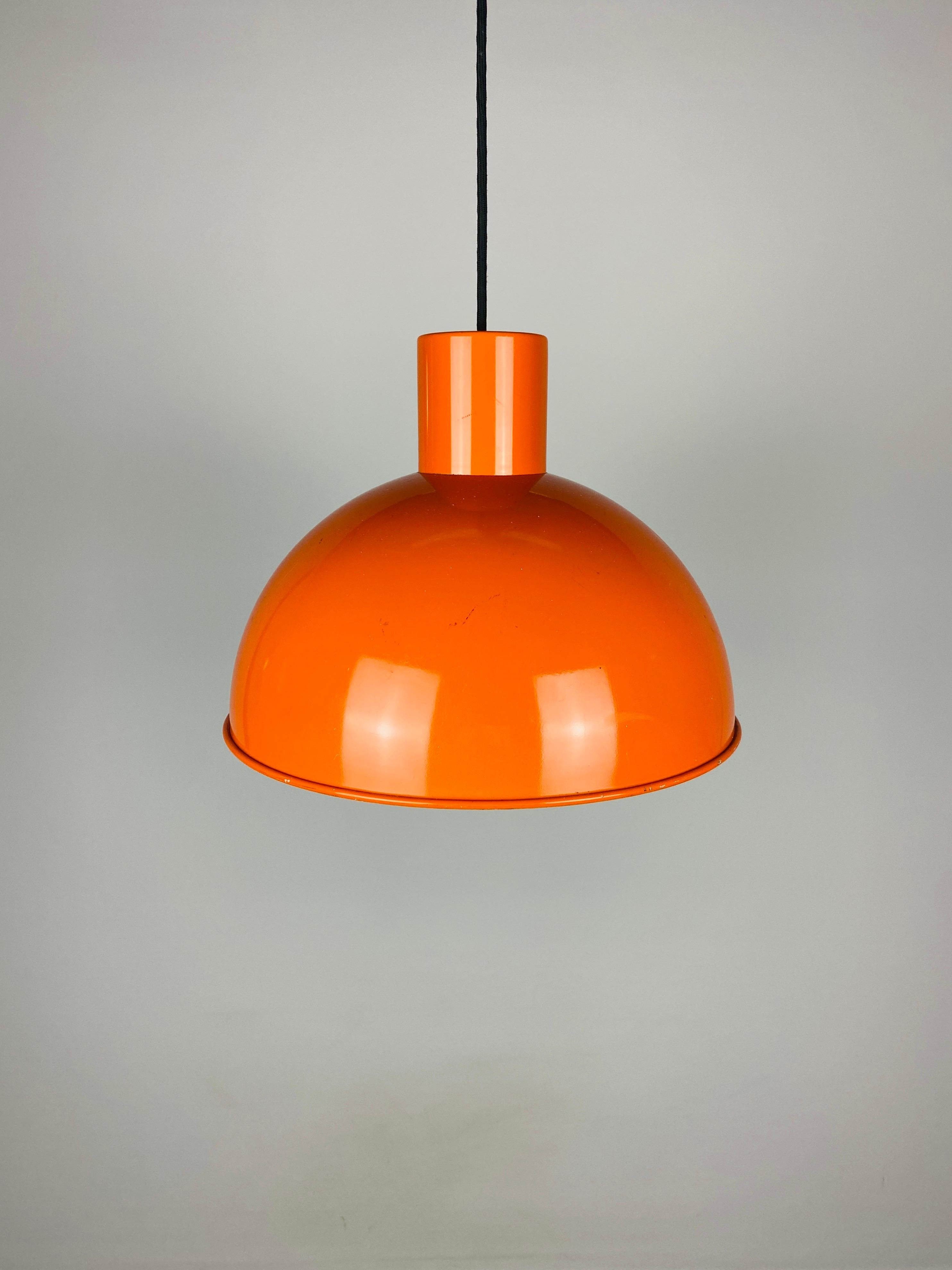 This orange hanging lamp was designed by Jo Hammerborg for Fog & Mørup in 1970. This Bunker model was made in three sizes: Mini (small), Midi (Medium) and Maxi (large). This is the medium version. Made of thick coated metal. The inside is white