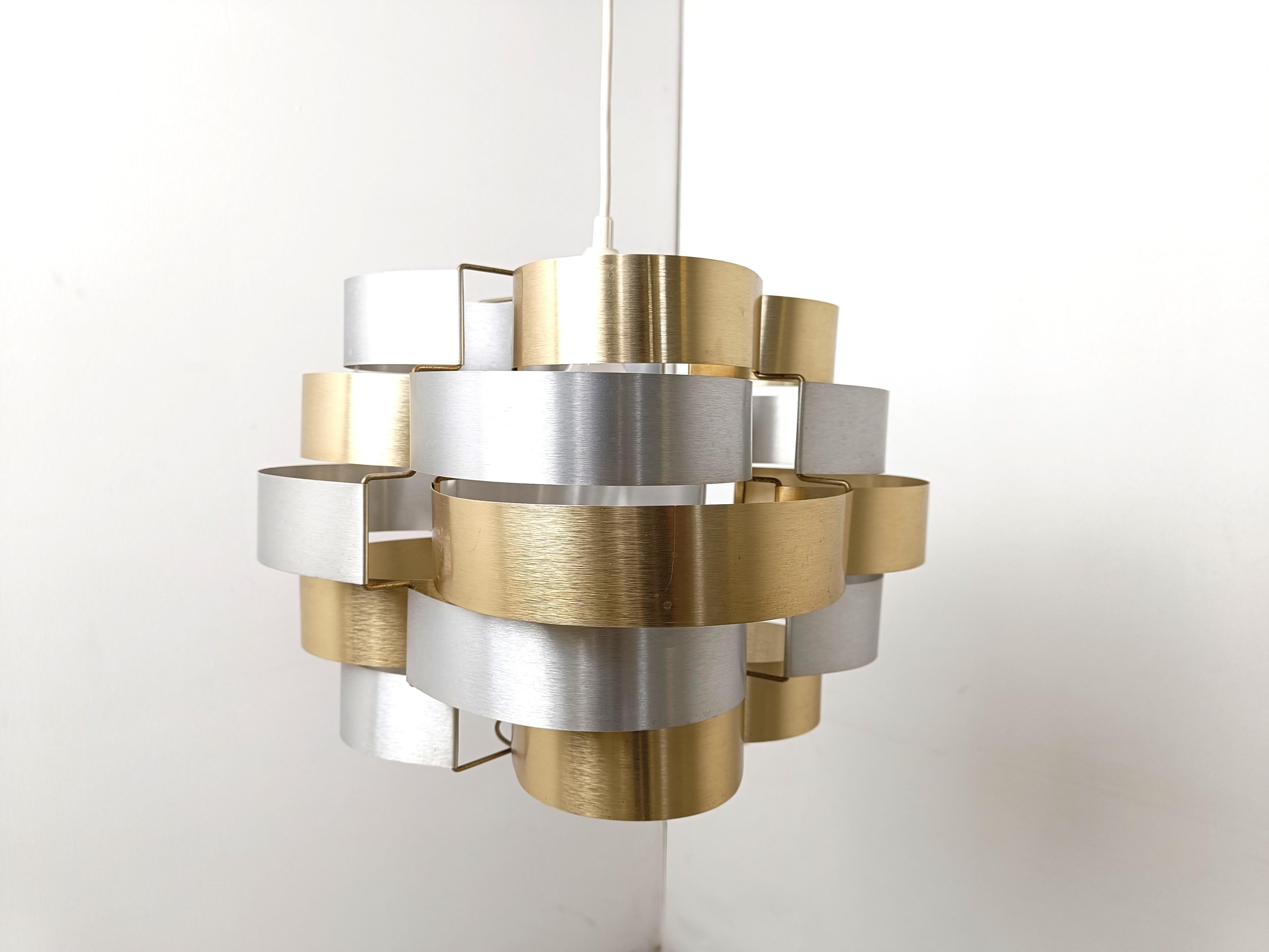 Space age pendant light with bent aluminum strips in silver and gold.

Designed by Max Sauze.

The light takes one E27 light bulb.

1960s - France

Good condition

Dimensions:
Height without cord (cable lenght can be requested) 35cm
Diameter: