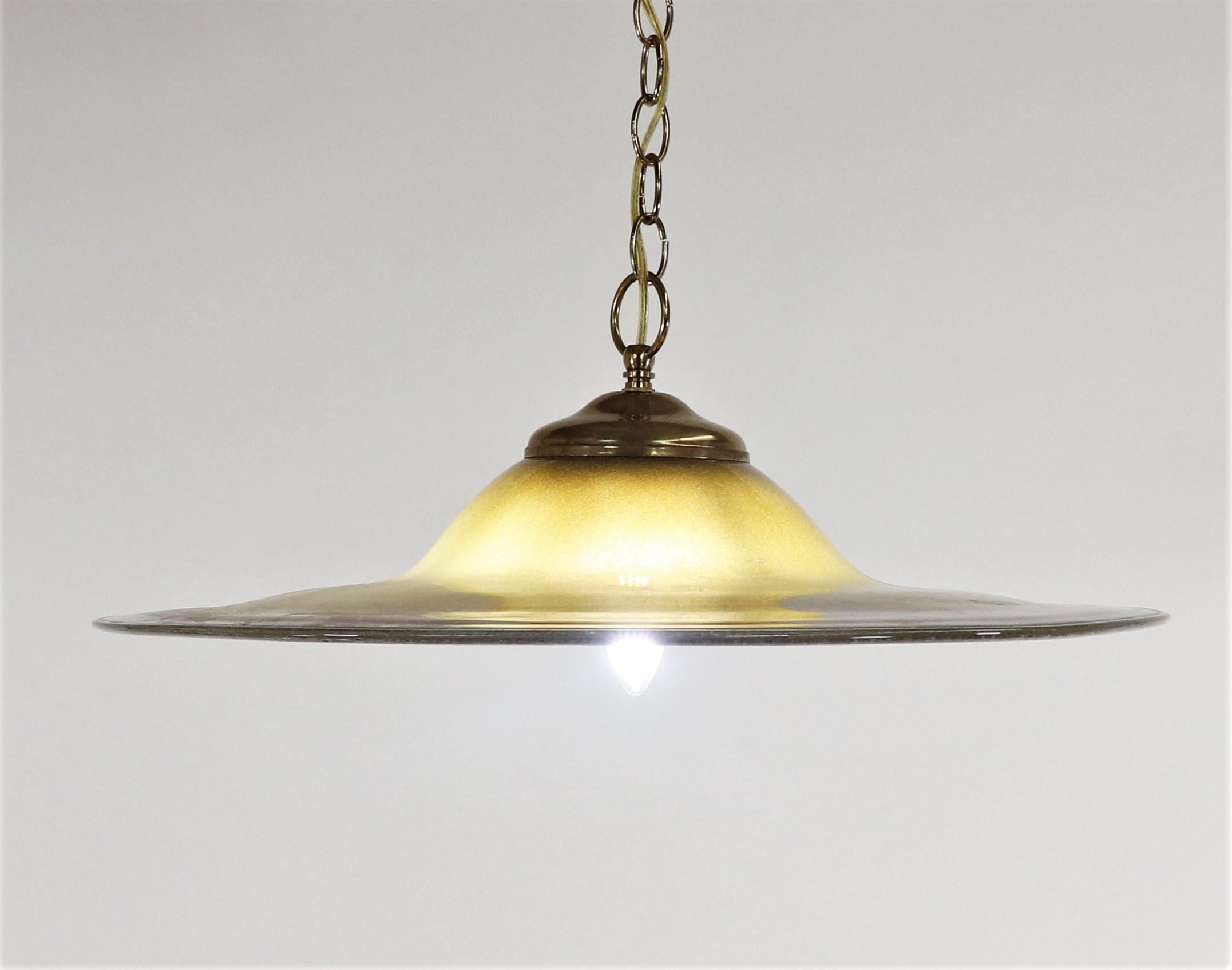 This mid-century modern Murano pendant lamp is a beautiful olive color with brick red and burnt sienna veins concentrated at the edge, reminiscent of a jasper stone. The subtle shifts in hue and density make this piece especially stunning.

The
