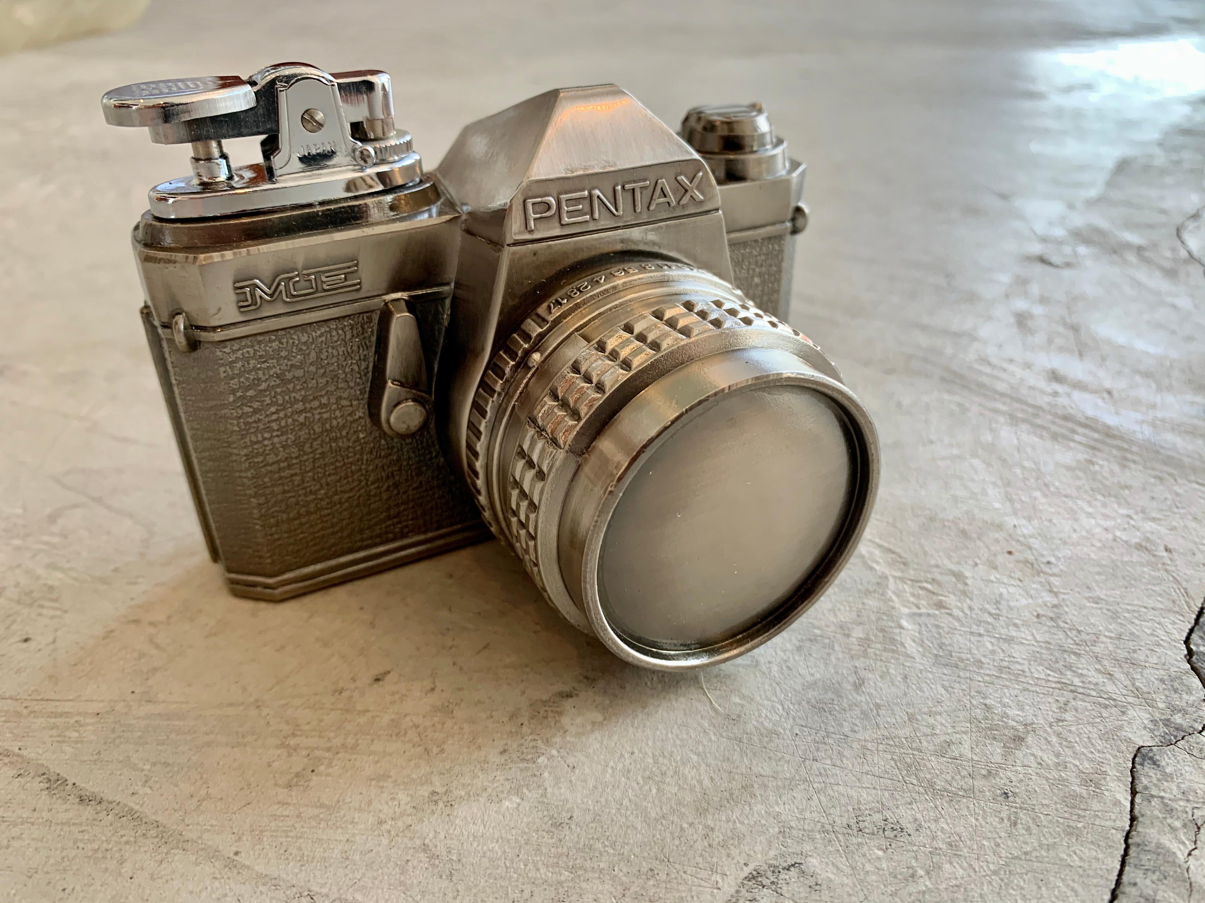 Cool vintage table lighter in the shape of a Pentax camera. Tons of detailing to metal camera. Made in Japan. Good working condition. Great object.

    