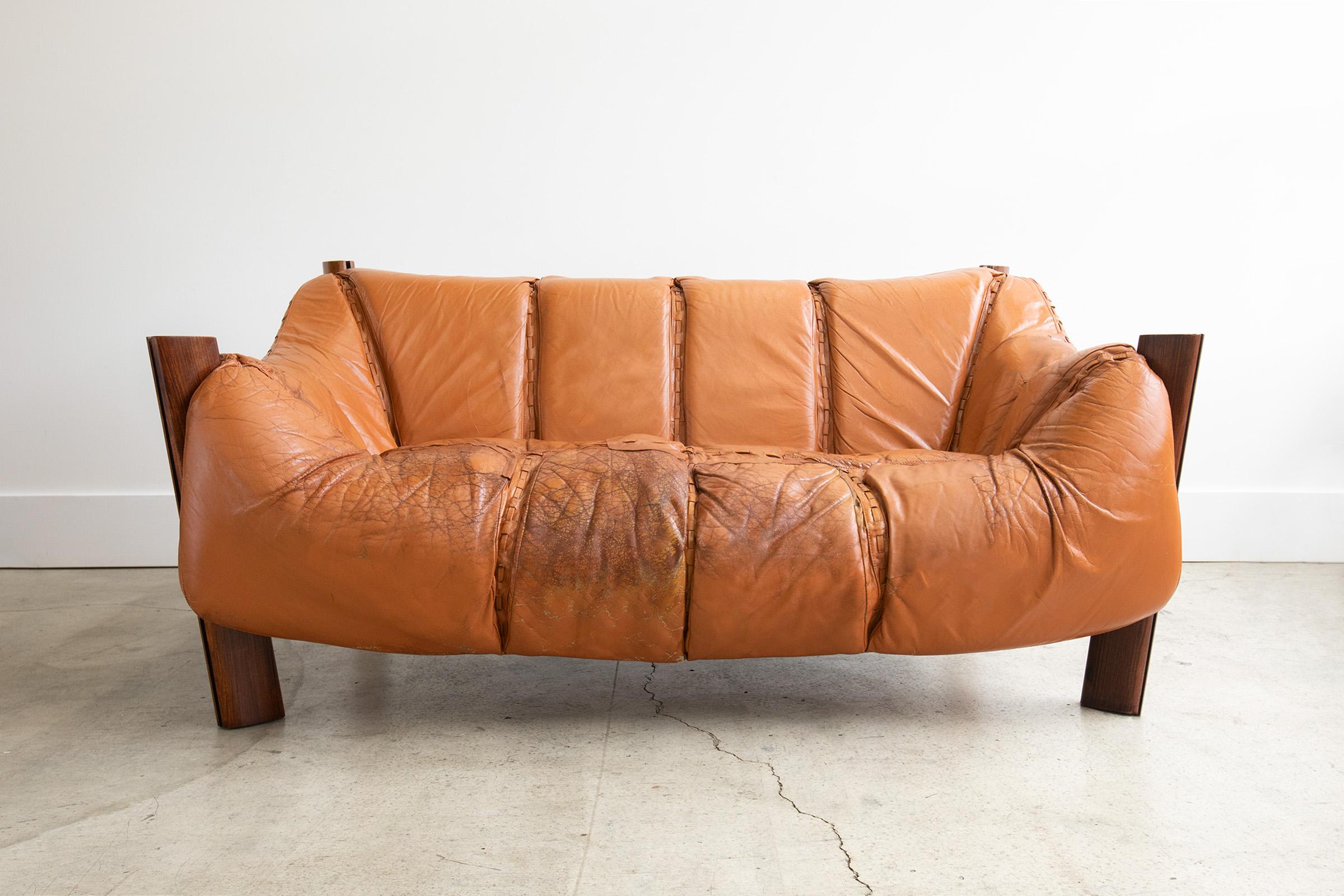 Rare Mid-Century Modern two-seat sofa by Percival Lafer in original Brazilian rosewood wood and upholstered in original cognac leather. In his unique designs, Lafer sought ergonomy and comfort making this sofa a true statement. The aged worn-in