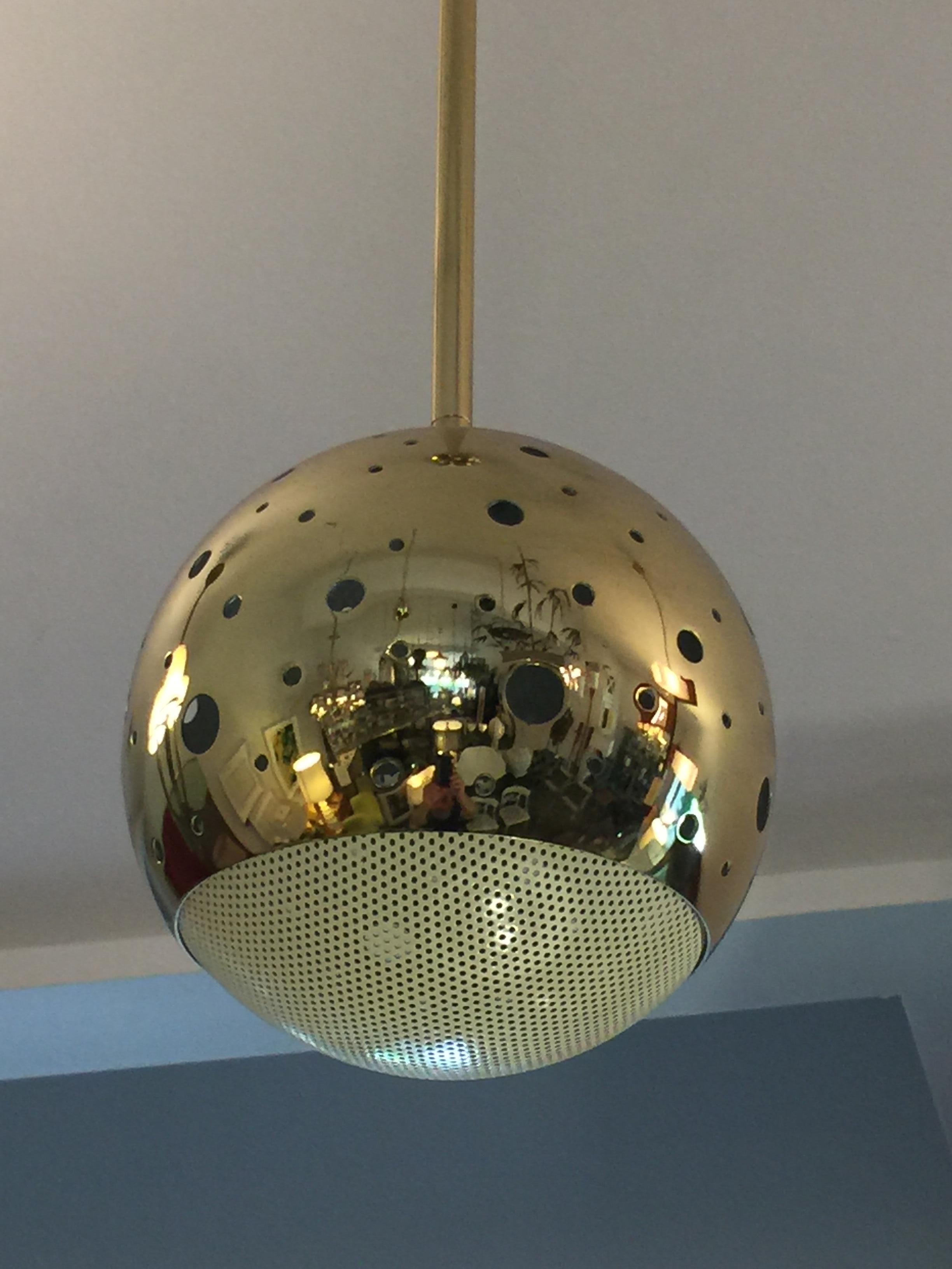 Polished brass perforated grill globe allows for light throughout fixture.