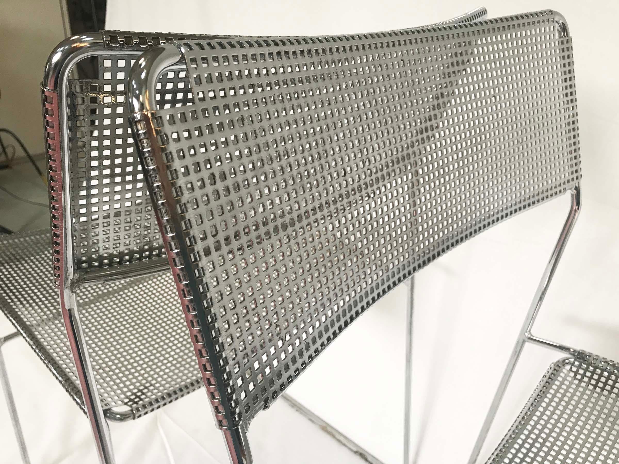 A pair of perforated chromed steel chairs designed by Niels Jorgen Haugesen in the 1970s and produced by Italian manufacturer Magis.
