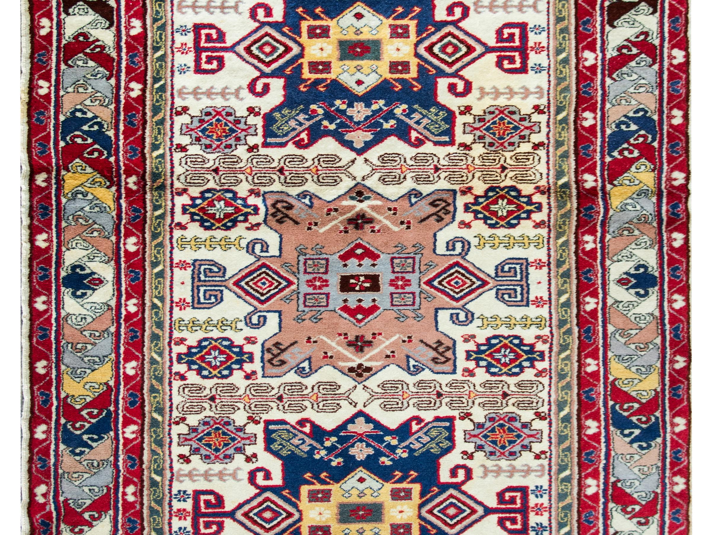 A wonderful late 20th century Persian Ardebil rug with three large stylized floral medallions amidst a field of densely woven stylized flowers and vines, and surrounded by a fantastic wide border with a large stylized floral pattern flanked by pairs