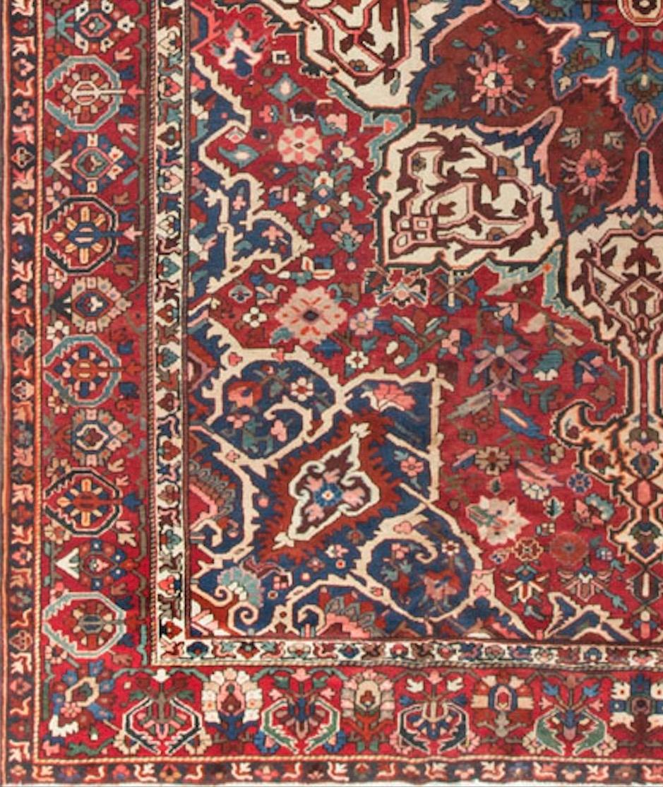 This antique Persian Bakhtiari rug, dating back to circa 1930, boasts a captivating and finely detailed design. Bakhtiari rugs are known for their geometric patterns and stylized floral motifs. The central field of this rug likely features a