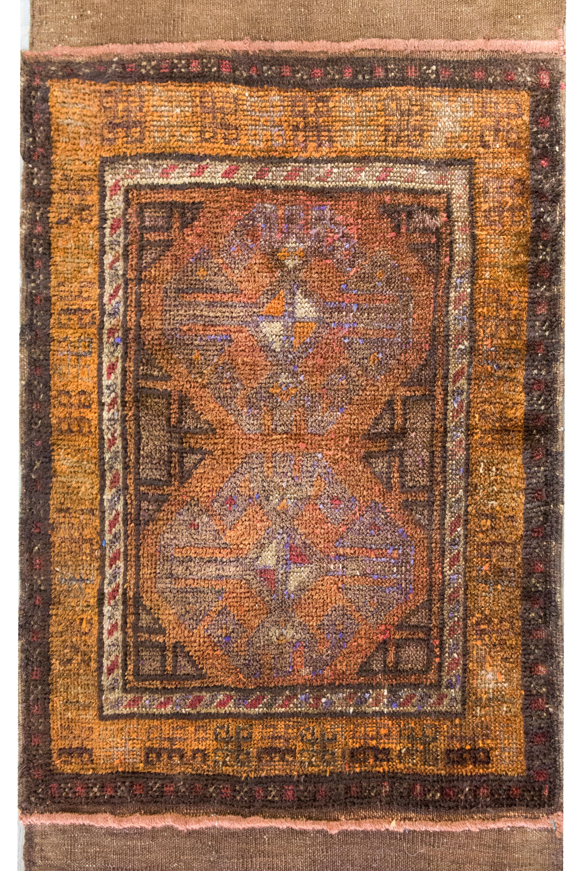 Un semplice ma sofisticato tappeto persiano Afghani Baluch vintage con due grandi medaglioni floreali ottagonali al centro, circondati da un semplice bordo con tre strisce geometriche a motivi floreali, affiancate da estremità intrecciate a kilim e