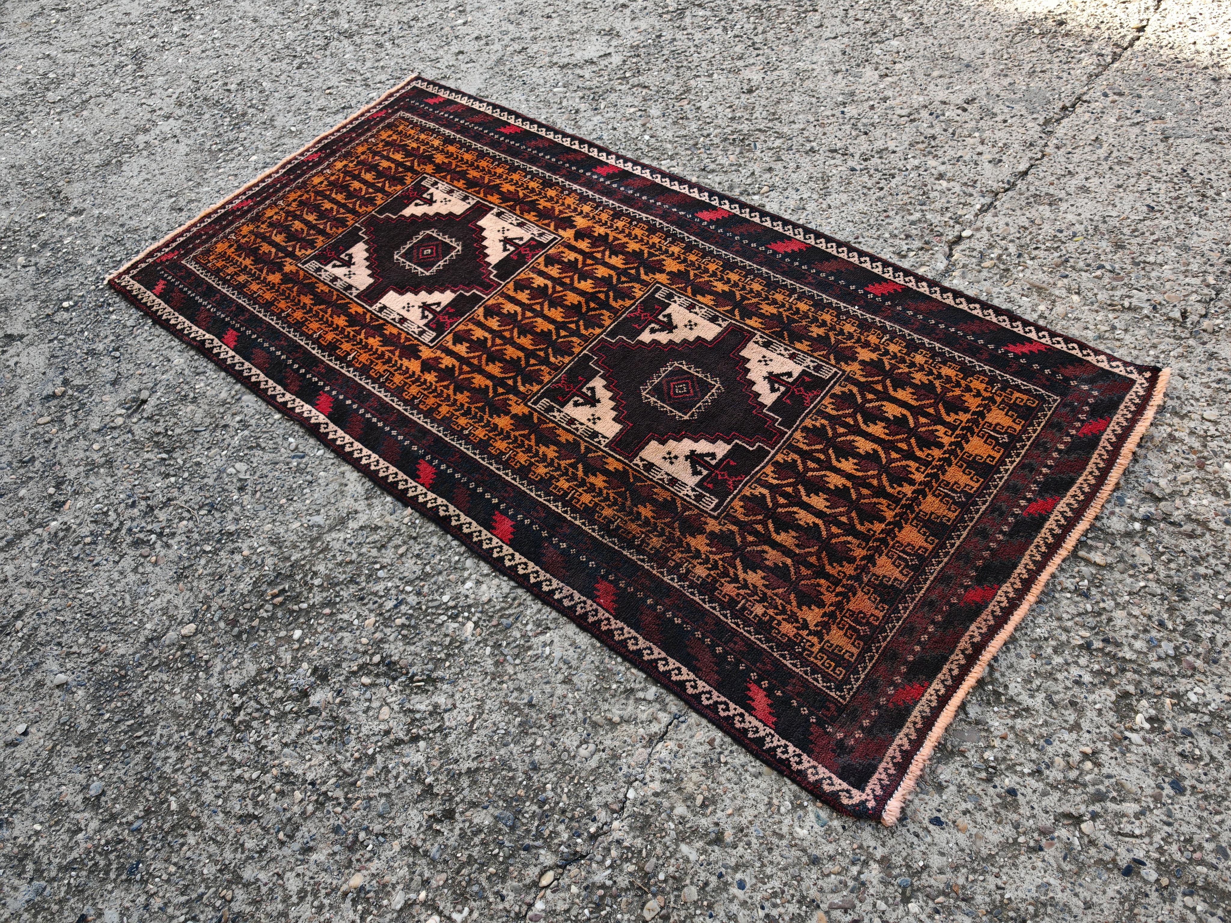 In questa inserzione troverai un affascinante tappeto persiano Baluch vintage. Le sue bellissime tonalità di marrone, arancione e crema e il suo bellissimo motivo geometrico lo rendono un'aggiunta perfetta a qualsiasi arredamento Mid Century Modern.