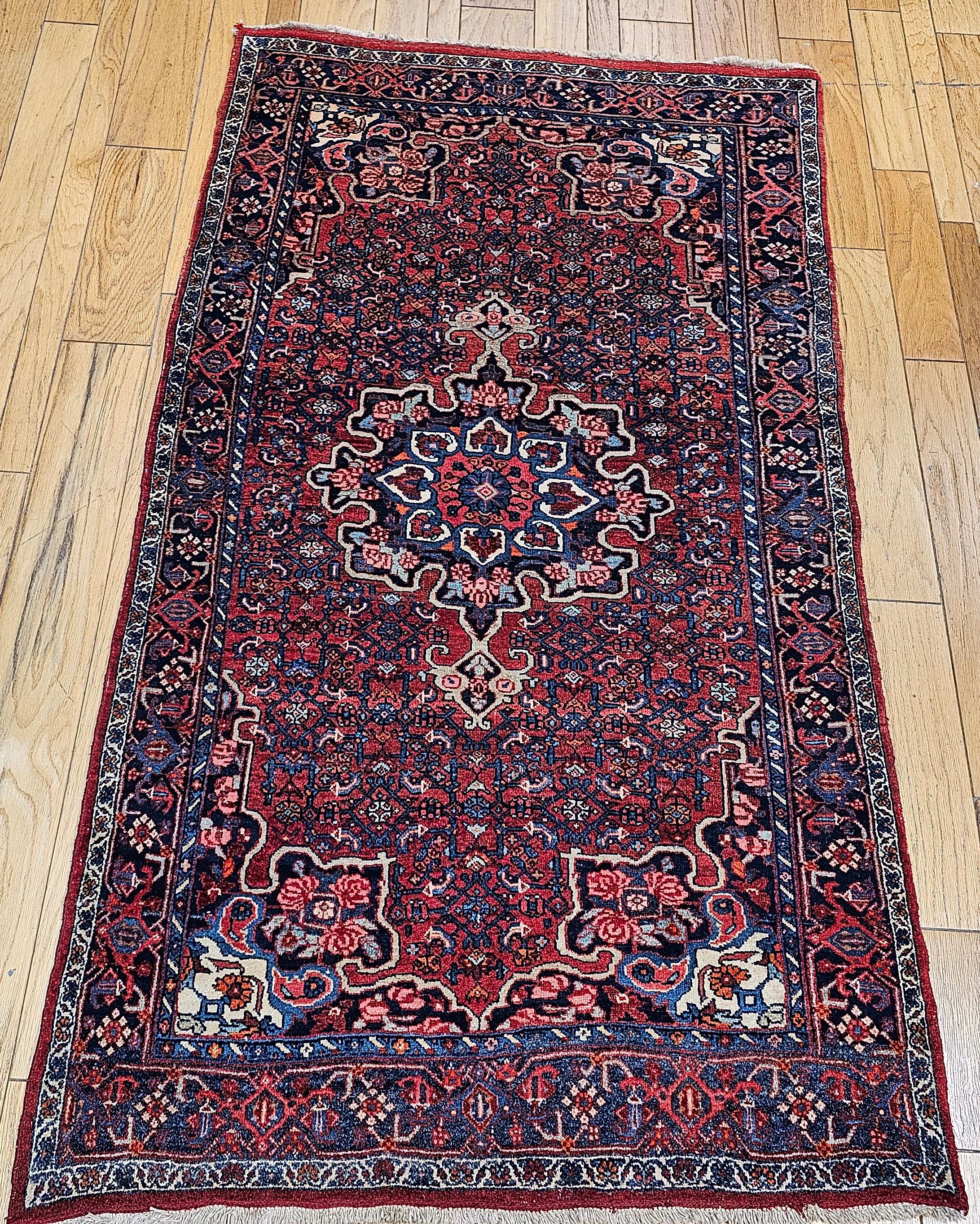 Persischer Bidar-Flächen- oder Galerie-Teppich mit floralem Medaillonmuster aus den frühen 1900er Jahren.  Der Teppich besteht aus einem zentralen Medaillon und Ankeranhängern in Blau-, Rot-, Elfenbein- und Rosatönen mit einer Umrandung aus dunklem