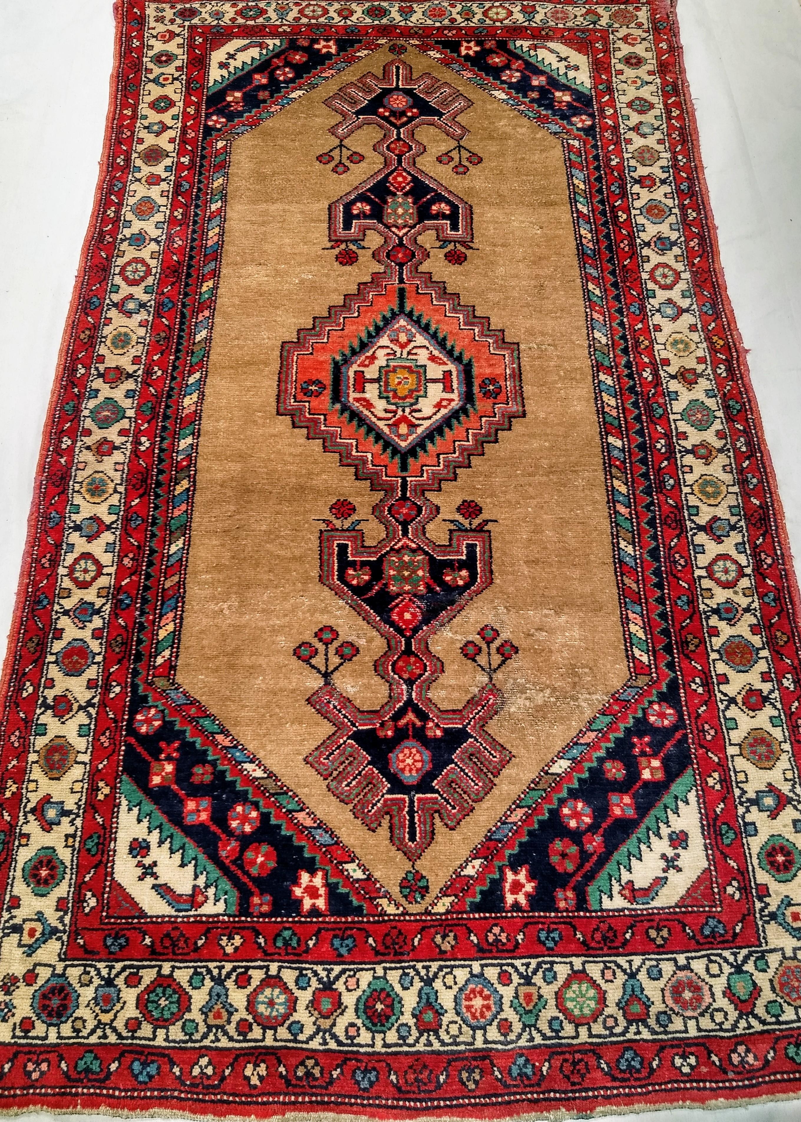 Bellissimo tappeto persiano d'epoca in pelo di cammello Hamadan del secondo quarto del 1900.  L'Hamadan in pelo di cammello ha un medaglione allungato che lo copre da un'estremità all'altra.   Il medaglione centrale è di colore rosa e crema, mentre