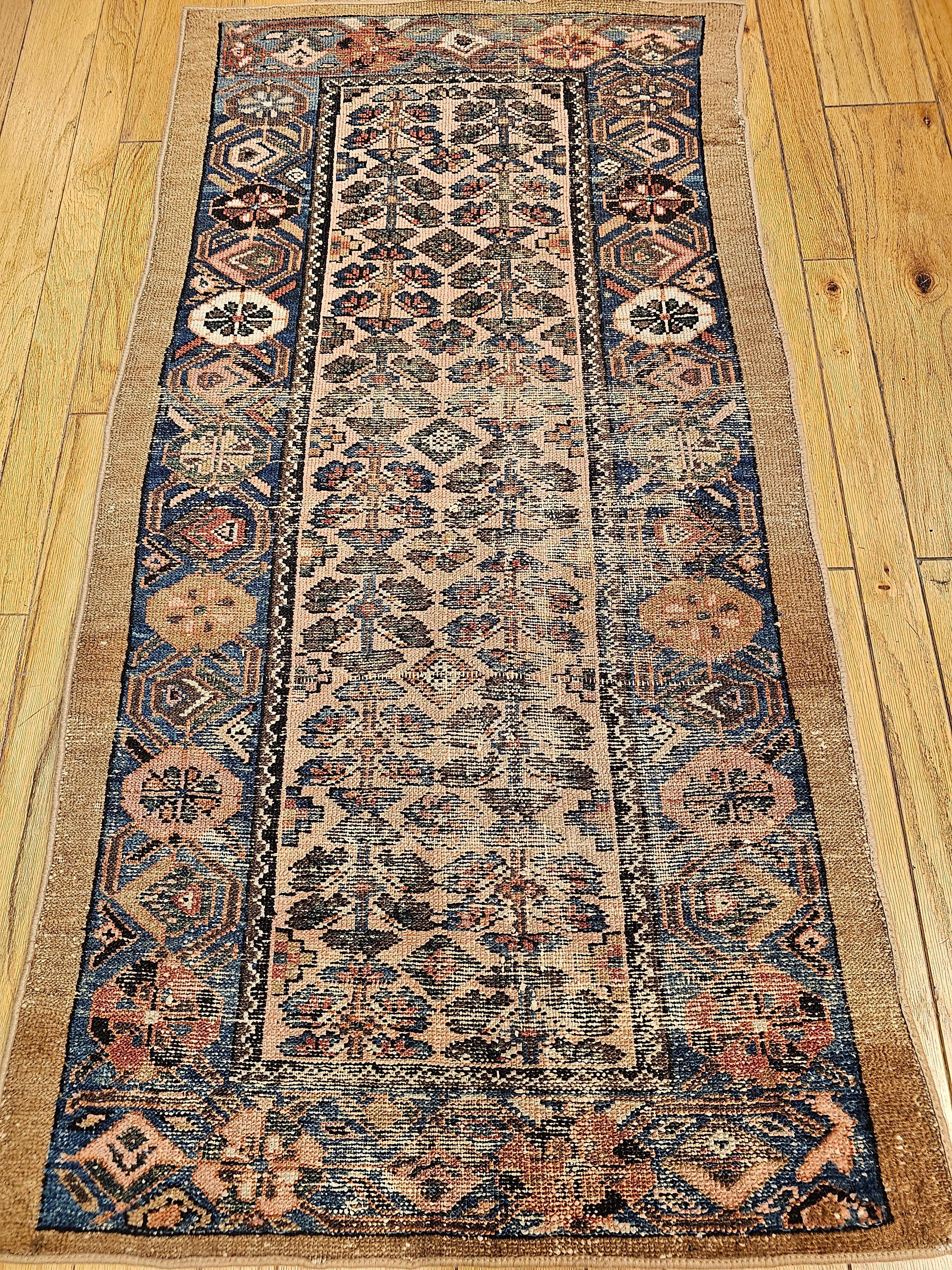 Vintage Persian Malayer Area Rug in Allover Geometric Design from the early 1900s.  The Persian Malayer has an extremely desirable  “allover geometric” design set on a pale pink background.  The rug has a beautiful border in an abrash French blue