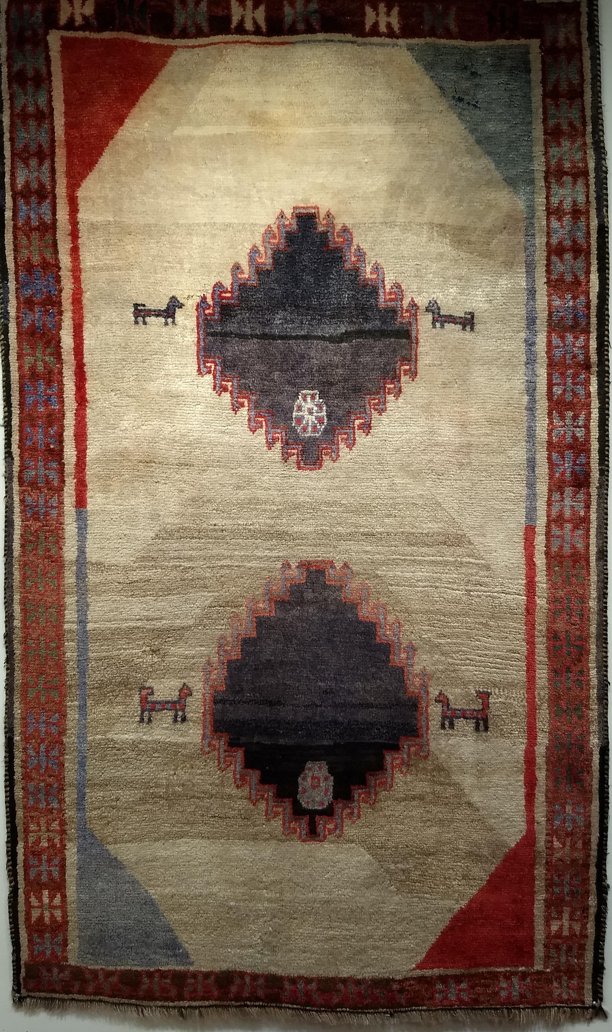 Beautiful vintage Gabbeh area rug from Persia.  The rug has a nice modern design and light colors with a straw or a beige field and accent colors of blue and red.  The rug was entirely hand-knotted with a wool pile on a wool foundation.   Gabbeh