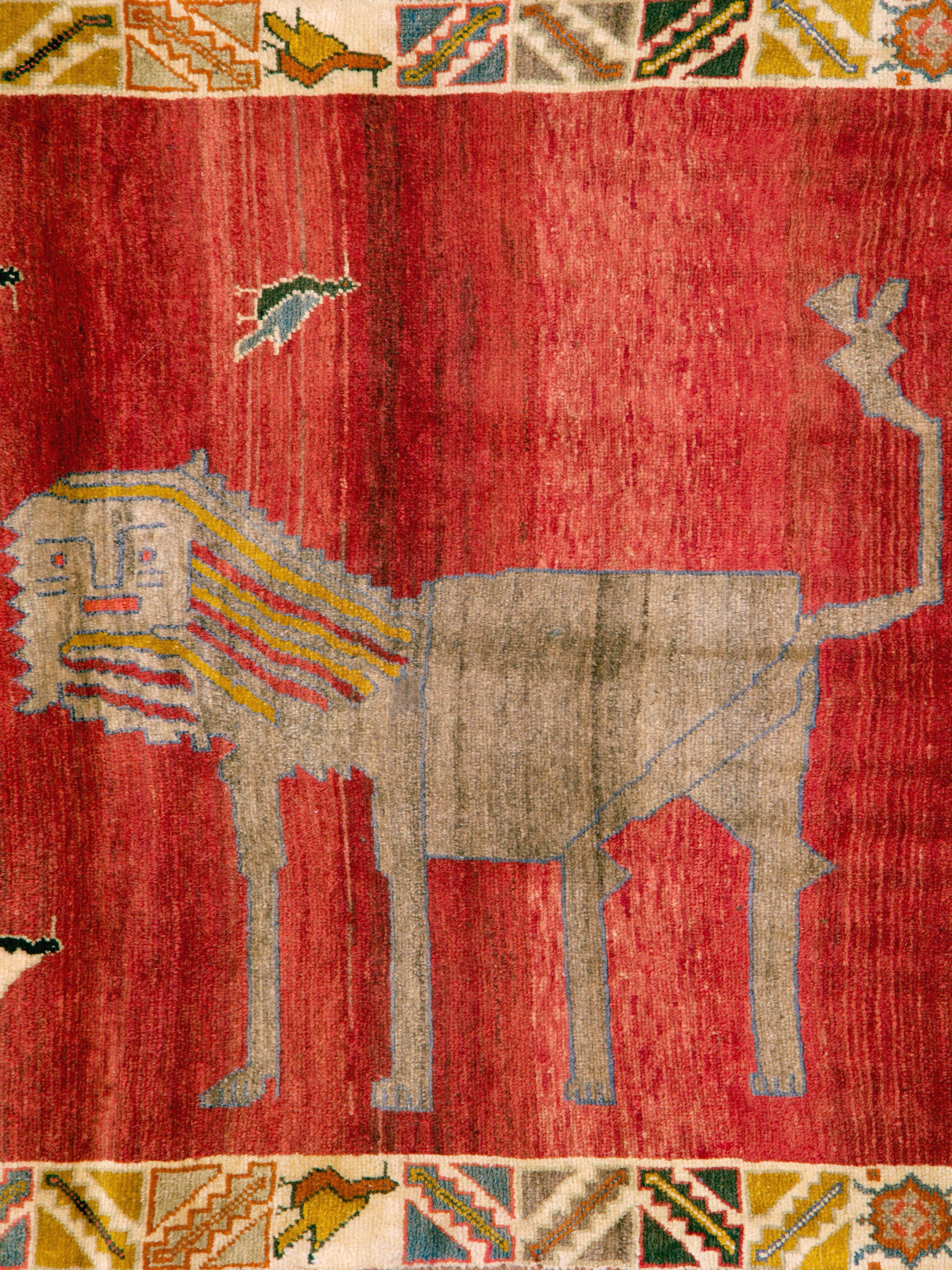 A vintage Persian Gabbeh rug with a pictorial design of 2, not so dangerous looking, lions. Woven during the mid-20th century, this rug has a very quirky, very fun, and definitely tribal appeal.