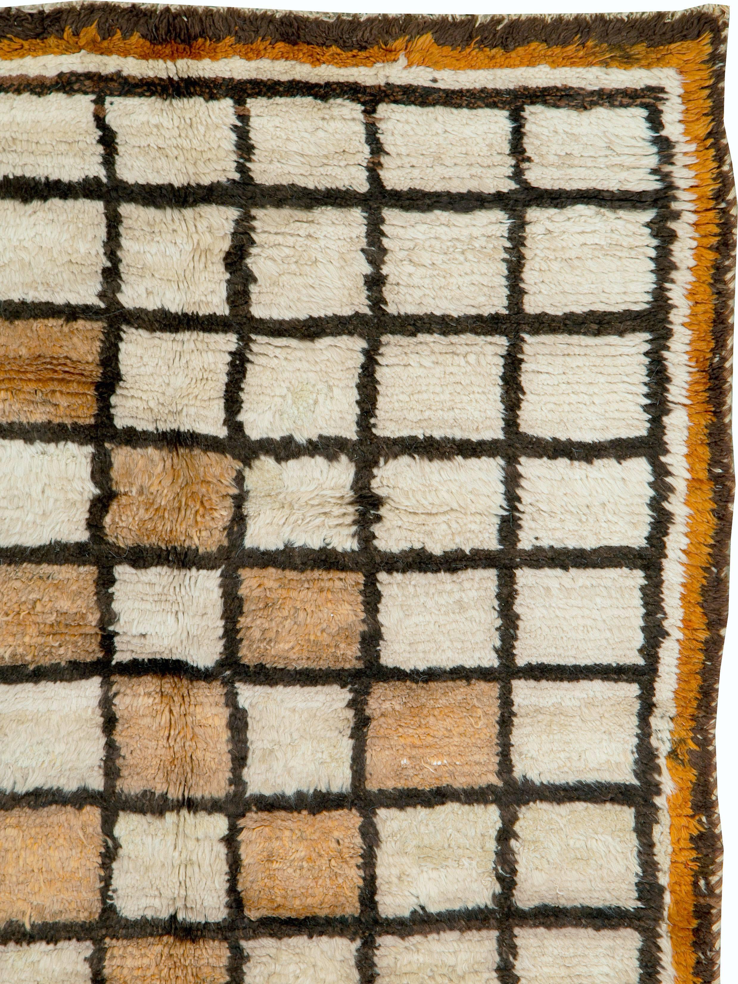 A vintage Persian Gabbeh rug from the mid-20th century. Gabbehs are woven by the south Persian Qashqai tribe for their own use.  The simpler square lattice on an ivory ground has camel panels making a zig-zag pattern. The look is modern and