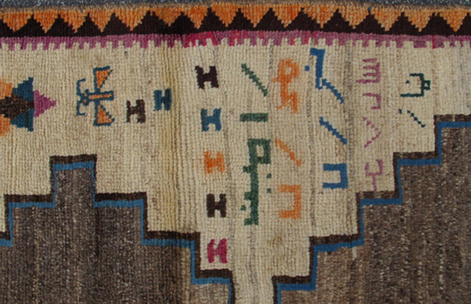 From Southern Persia, Gabbeh vintage rug with medallions in brown, cream, red, blue and green, rug H-1205-05, country of origin / type: Iran / Gabbeh, circa 1950

This high-pile mid-20th century vintage Persian Gabbeh carpet consists of large