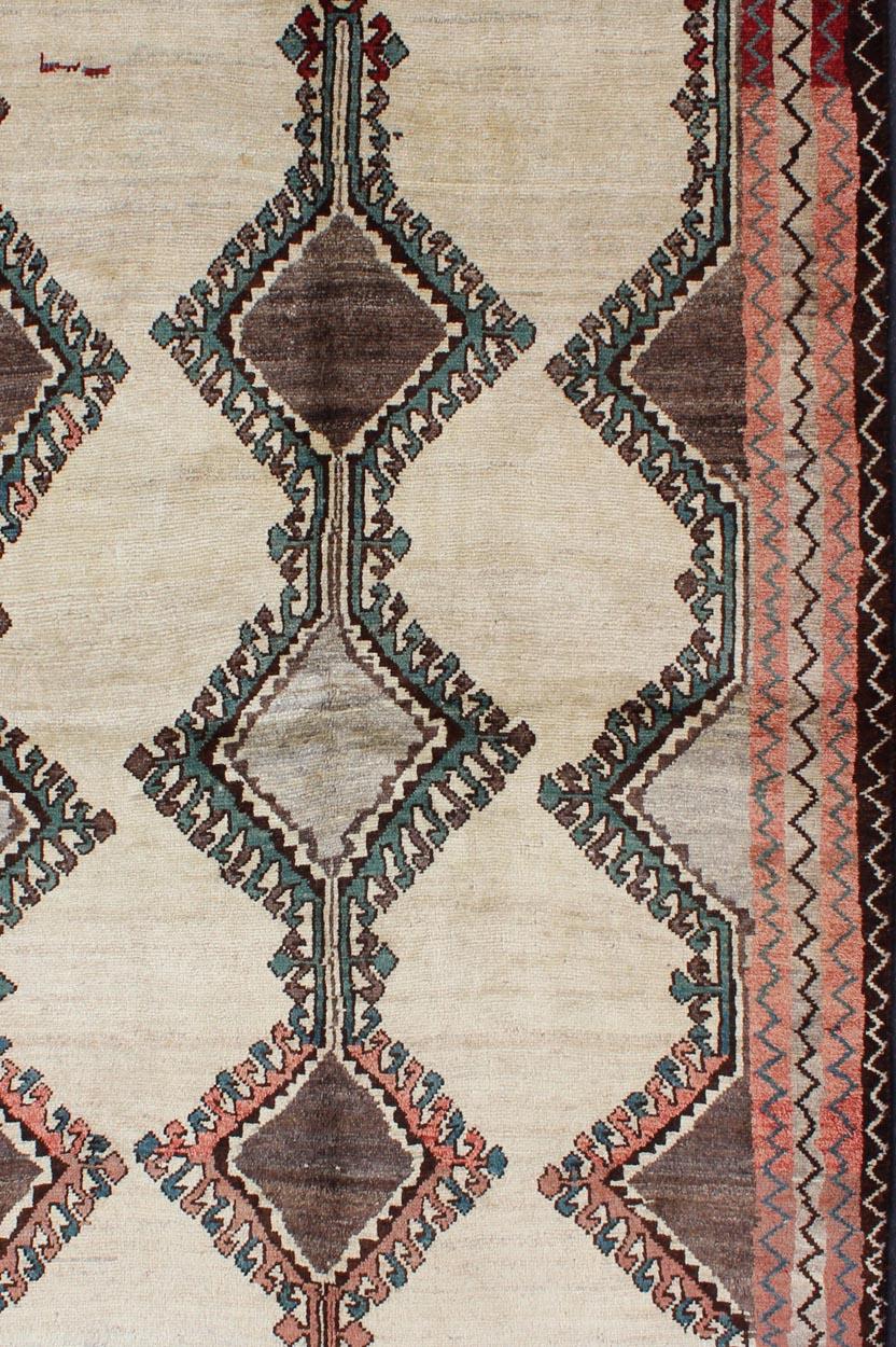 Persian Gabbeh vintage rug with medallions in brown, cream, red and green, rug h-1205-06, country of origin / type: Iran / Gabbeh, circa 1950

This mid-20th century vintage Persian Gabbeh carpet consists of large tribal medallions with latch hook
