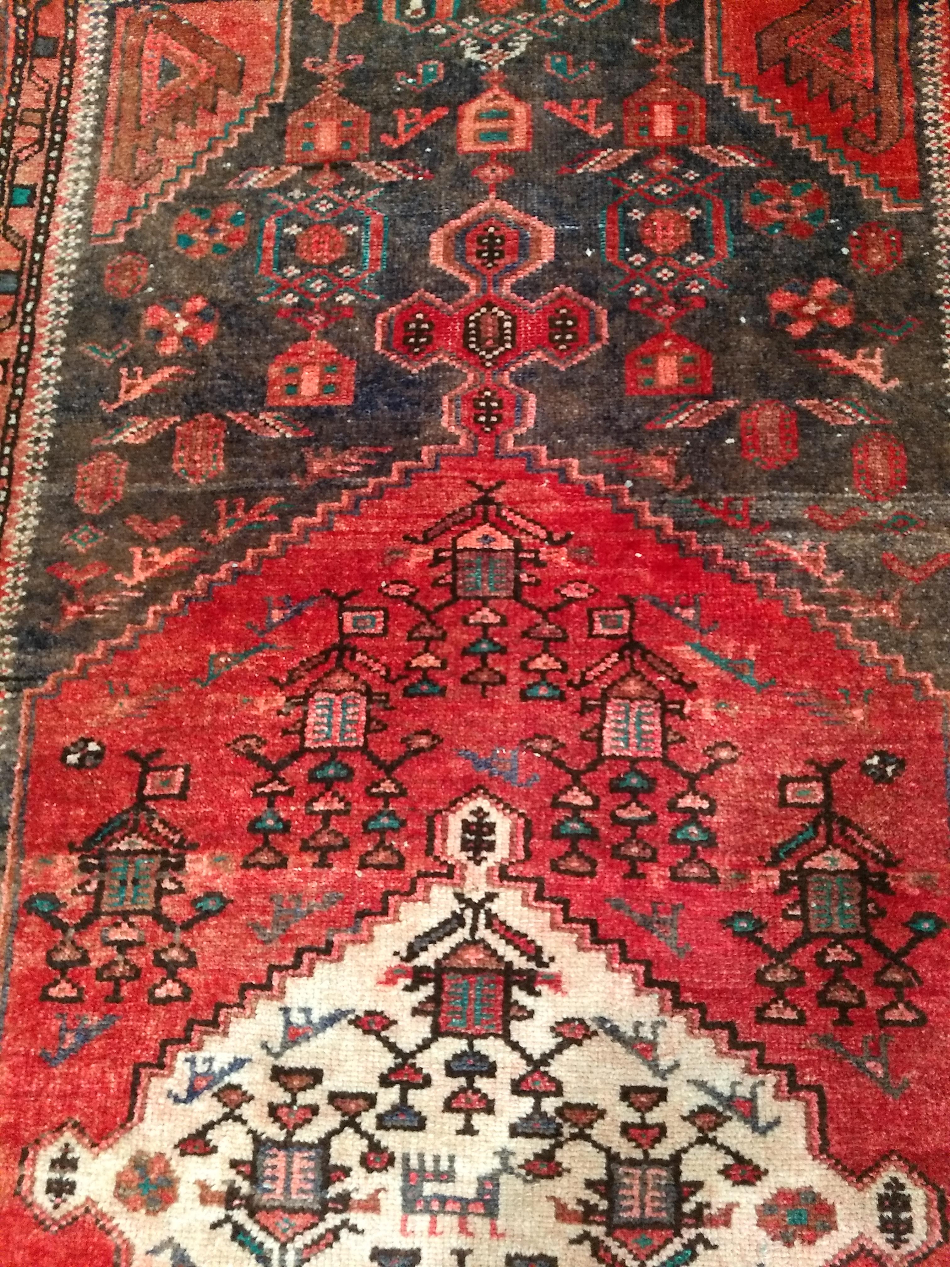 A beautiful hand woven Persian Hamadan area rug in medallion pattern in moss green, red, ivory, and gray colors from the 2nd quarter of the 1900s. The overall design of the rug is considered “tribal” or “rustic”. The rug has a central medallion in a
