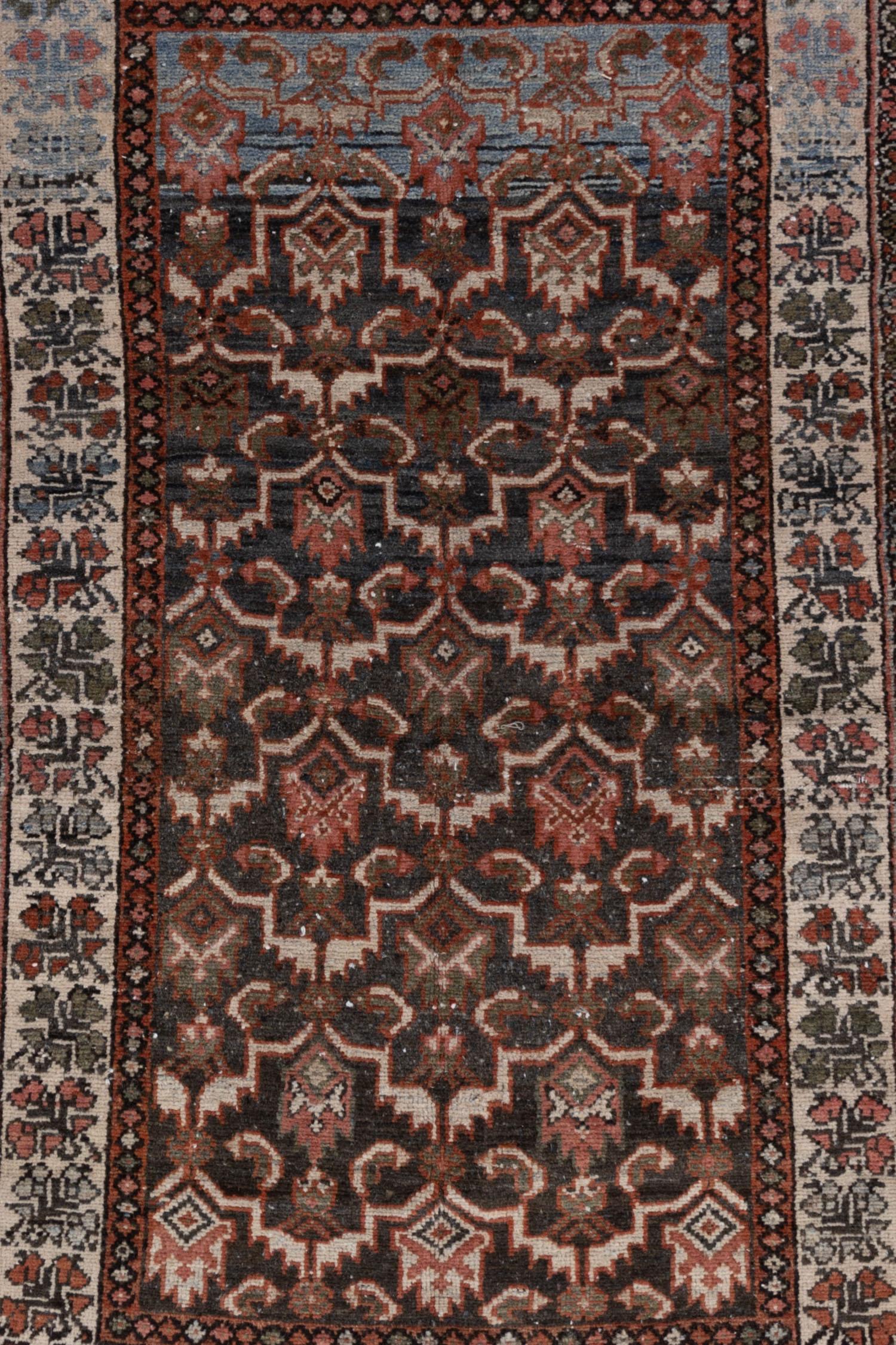 Lovely deep toned Persian scatter rug with a masculine colorway and strong motif. Please note that the photos depict the edges in a pre-repair condition. The borders will be secured and repaired before shipping. 