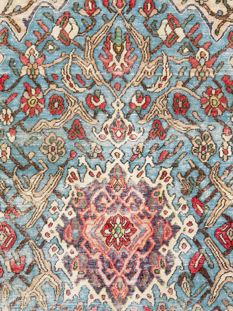 Ein alter persischer Hamadan-Teppich. Obwohl etwas abgenutzt und im Shabby-Chic-Zustand, präsentiert diese Streuung ein attraktives hellblaues Feld mit einem doppelt hängenden Medaillon mit komplexer ecrufarbener Kontur. In den chamoisfarbenen Ecken