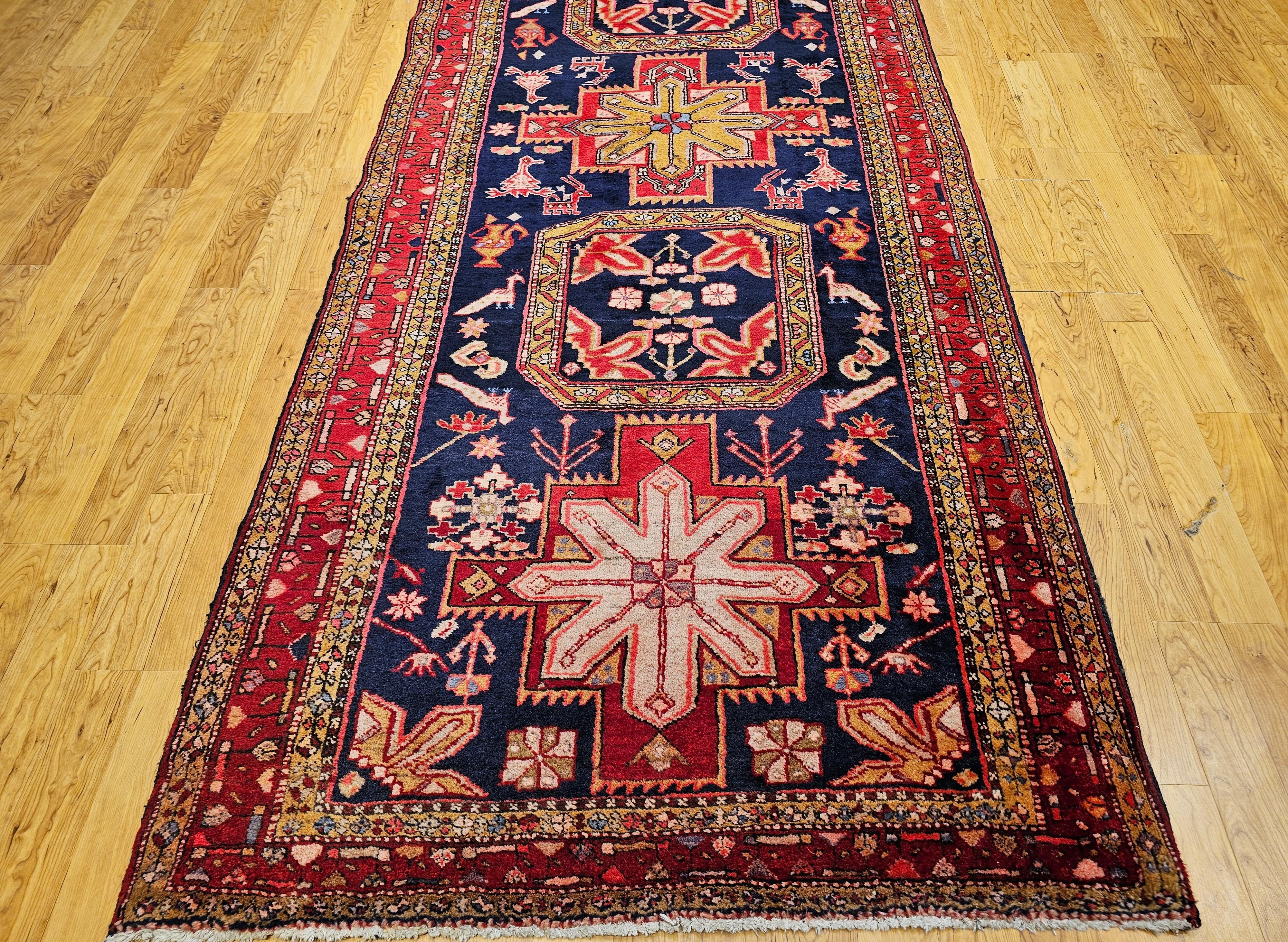 Bello e colorato.  È così che si potrebbe descrivere il bellissimo runner persiano Hamadan in un brillante campo blu navy con un bordo rosso.  Il tappeto persiano Hamadan annodato a mano può essere utilizzato sia come tappeto da galleria che come