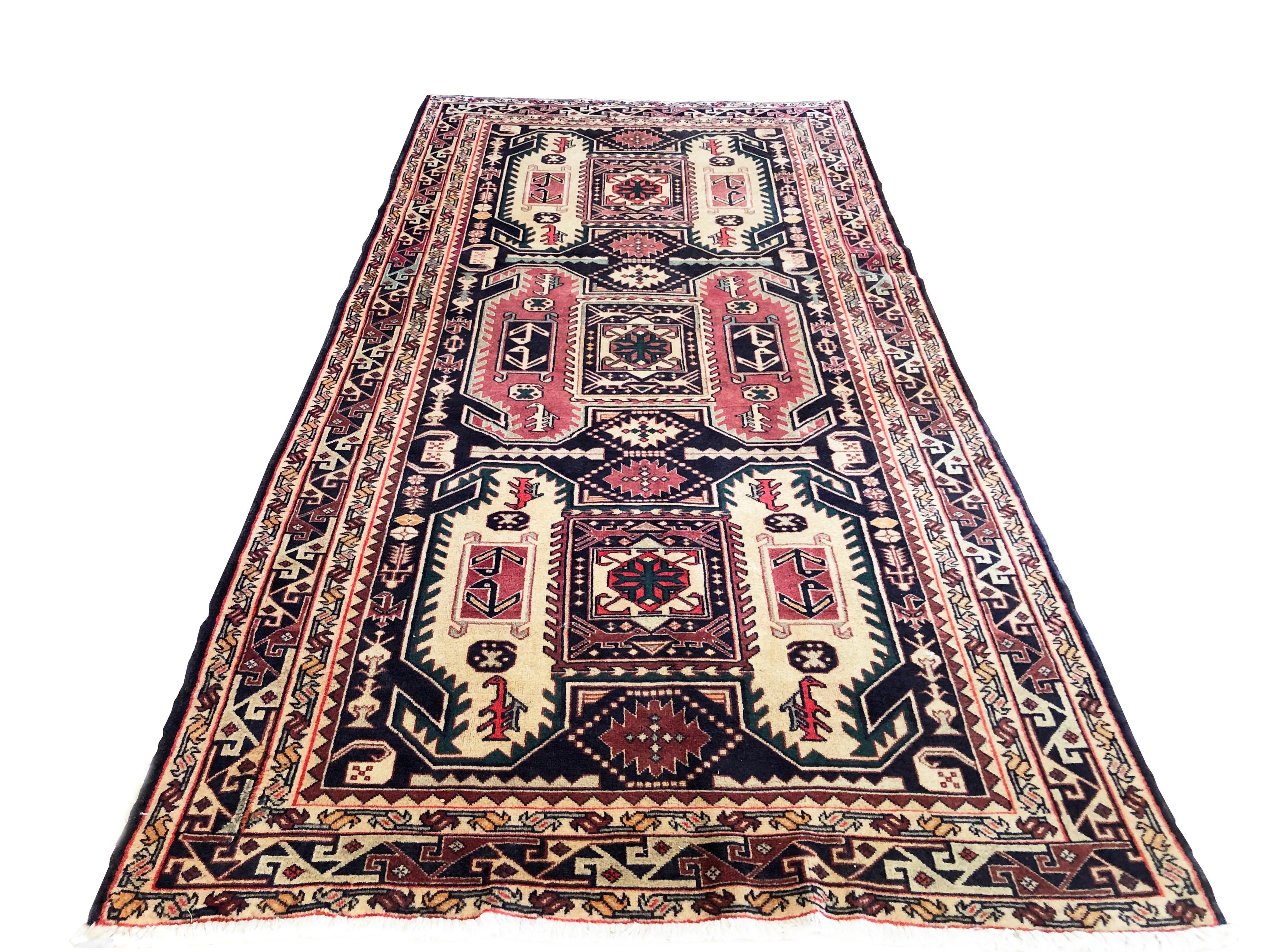 This rug is knotted in the province of Azarbayjan in north-west of Iran. The design is geometric with repeated medallion. The base color and border color is dark blue. The pile is wool with cotton foundation. The size is 5 feet wide by 9 feet 10