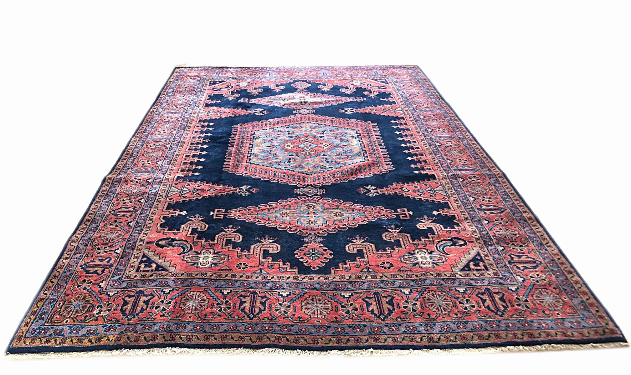 This authentic Persian Viss rug has wool pile and cotton foundation. The age of this rug is almost 50 years old. The base color is dark blue and the border color is salmon. This beautiful piece has a hexagonal shape medallion. The size of this rug