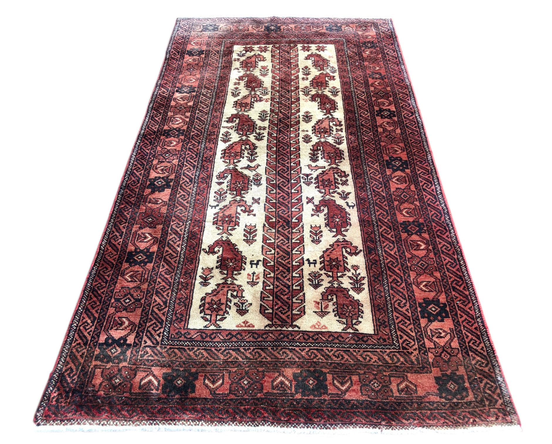 This authentic Persian Baluchi rug has wool pile and cotton foundation which are hand-knotted by the nomads of Baluchi. The age of this rug is almost 50 years old. The size of this rug is 3 feet 5 inches wide by 6 feet 4 inches tall. Baluchi rugs