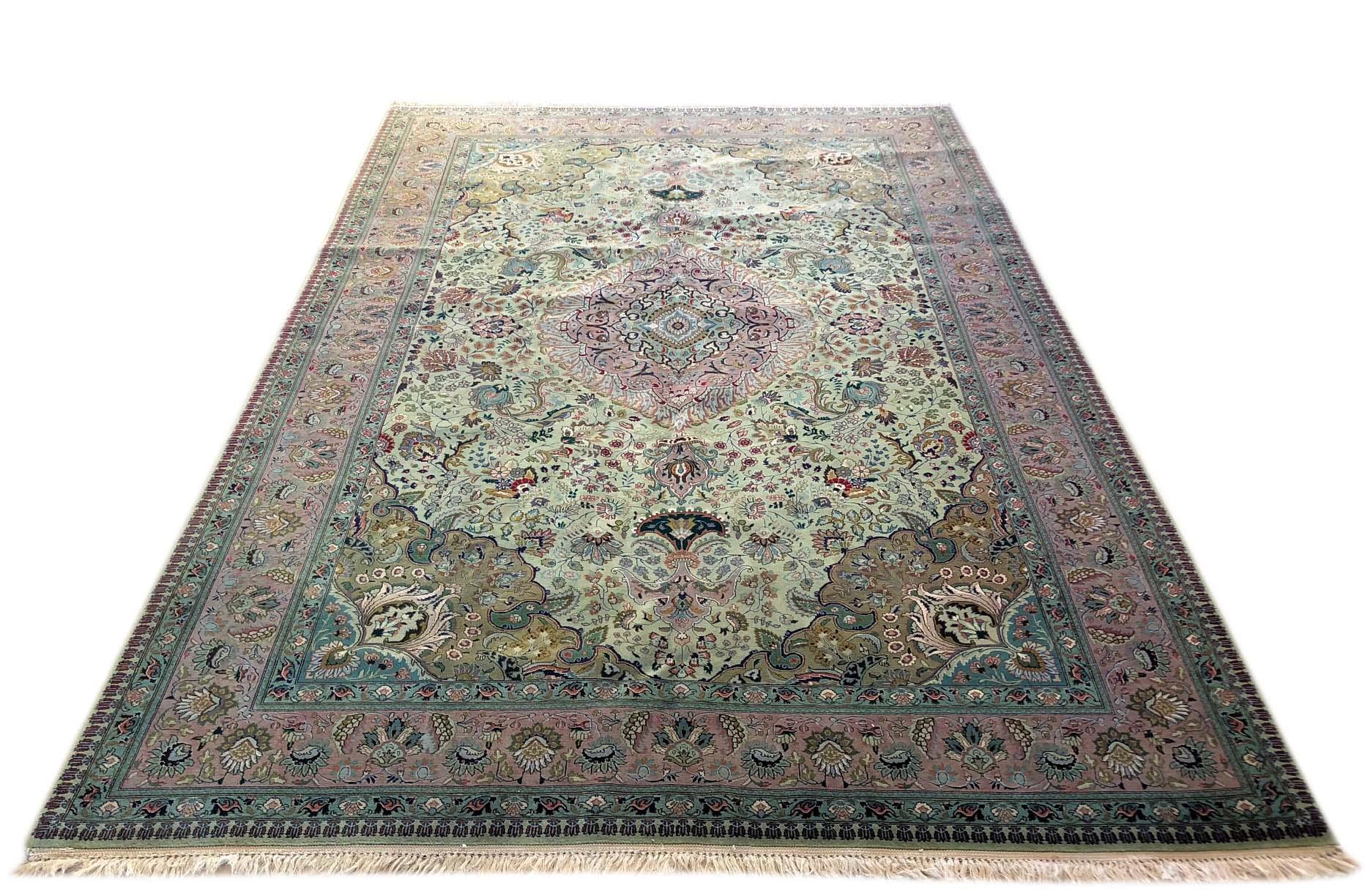 This vintage Persian Tabriz rug has wool pile and cotton foundation with floral pattern. An extremely beautiful color combination including an unusual green color makes this piece a very unique rug for your home. The base color is green and the
