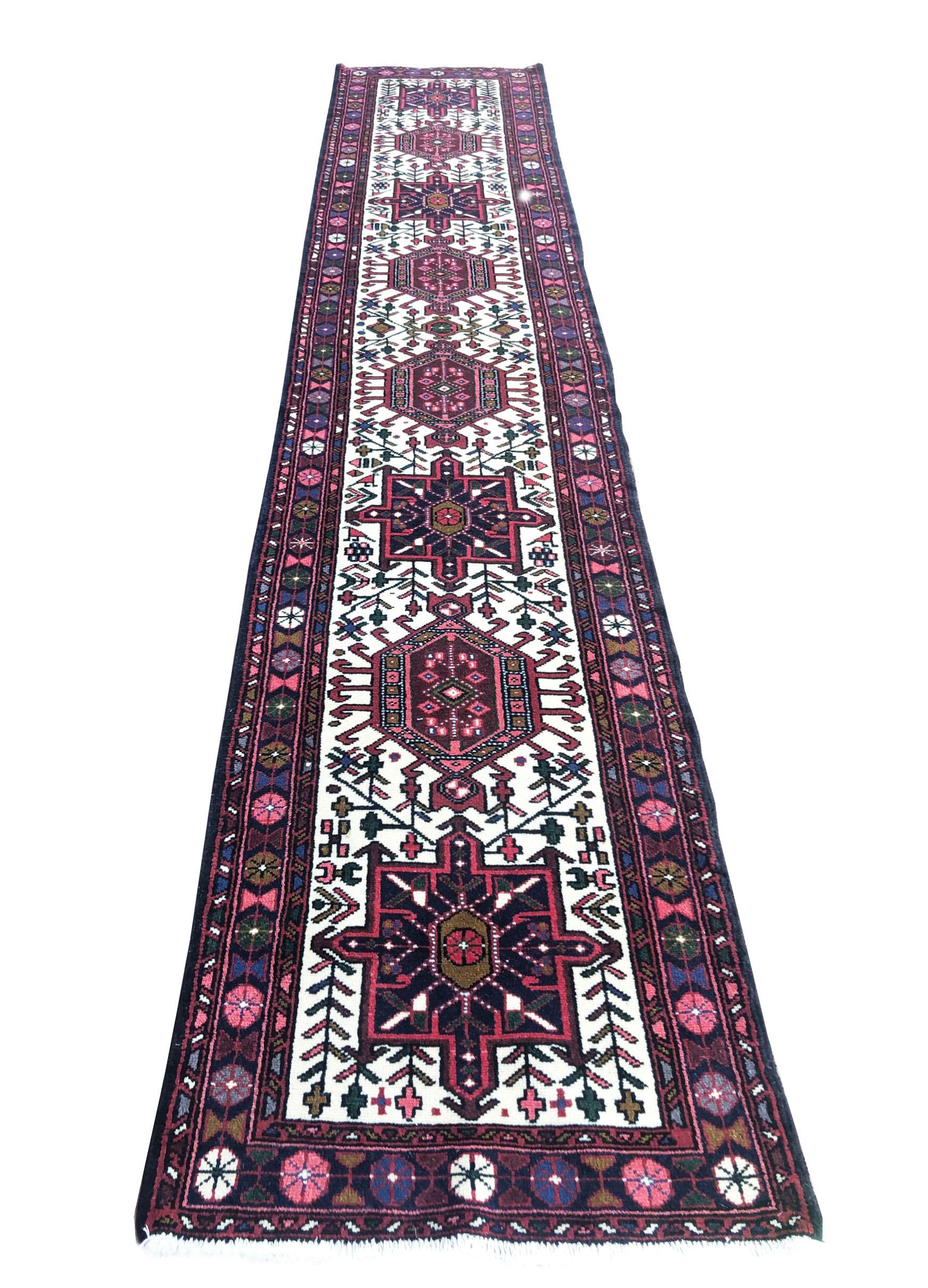 This Authentic Persian Karajeh runner from the mid-20th century has wool pile and cotton foundation. The design is tribal (Heriz Style) and it has repeated medallions and each medallion has different design from another. This piece is very