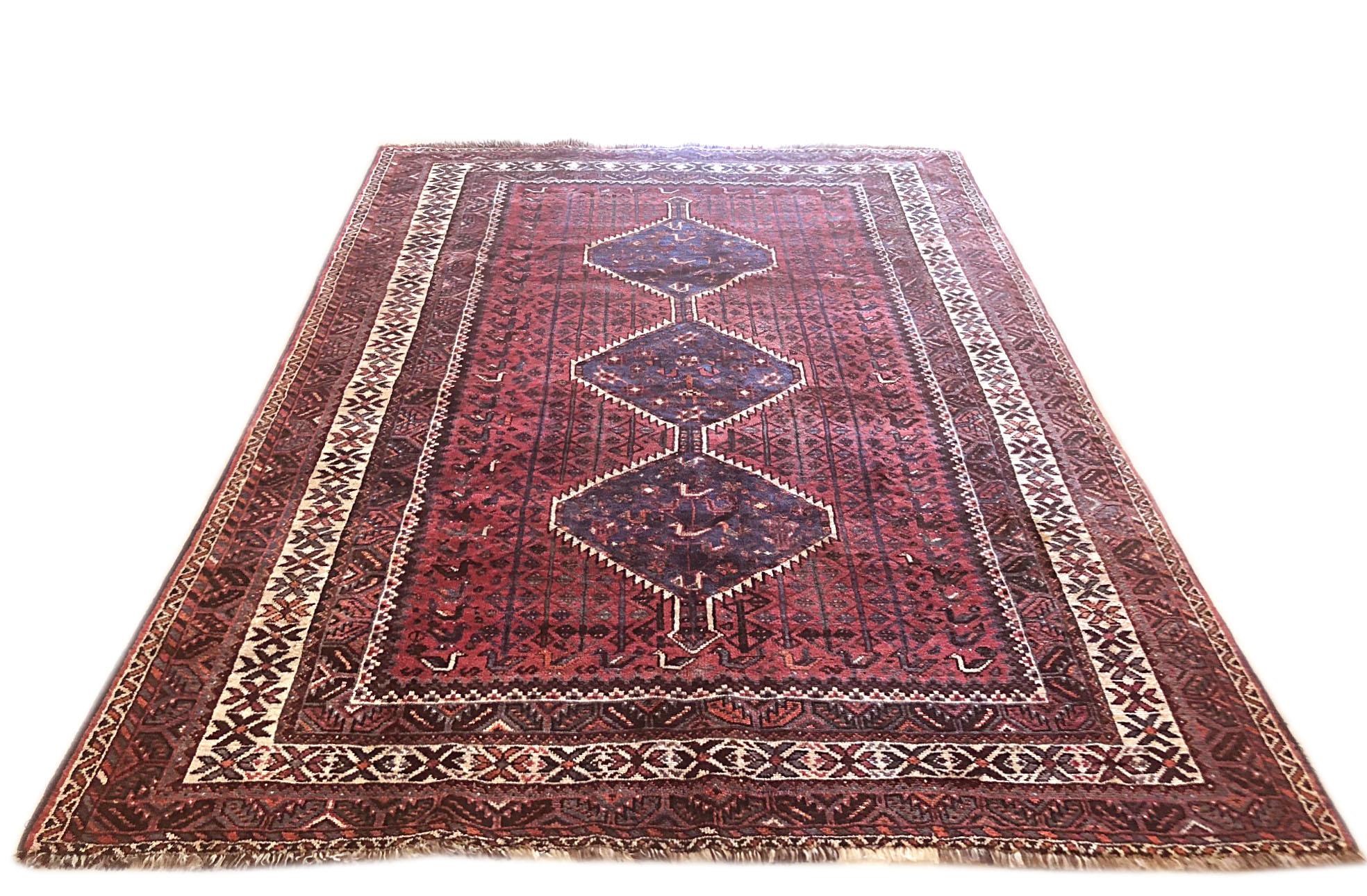 This rug is an authentic rug from Iran, Shiraz. The pile and foundation are wool. The base color is red and cream and multi. The design is geometric with repeated medallion. This piece is a great choice for both traditional and transitional home