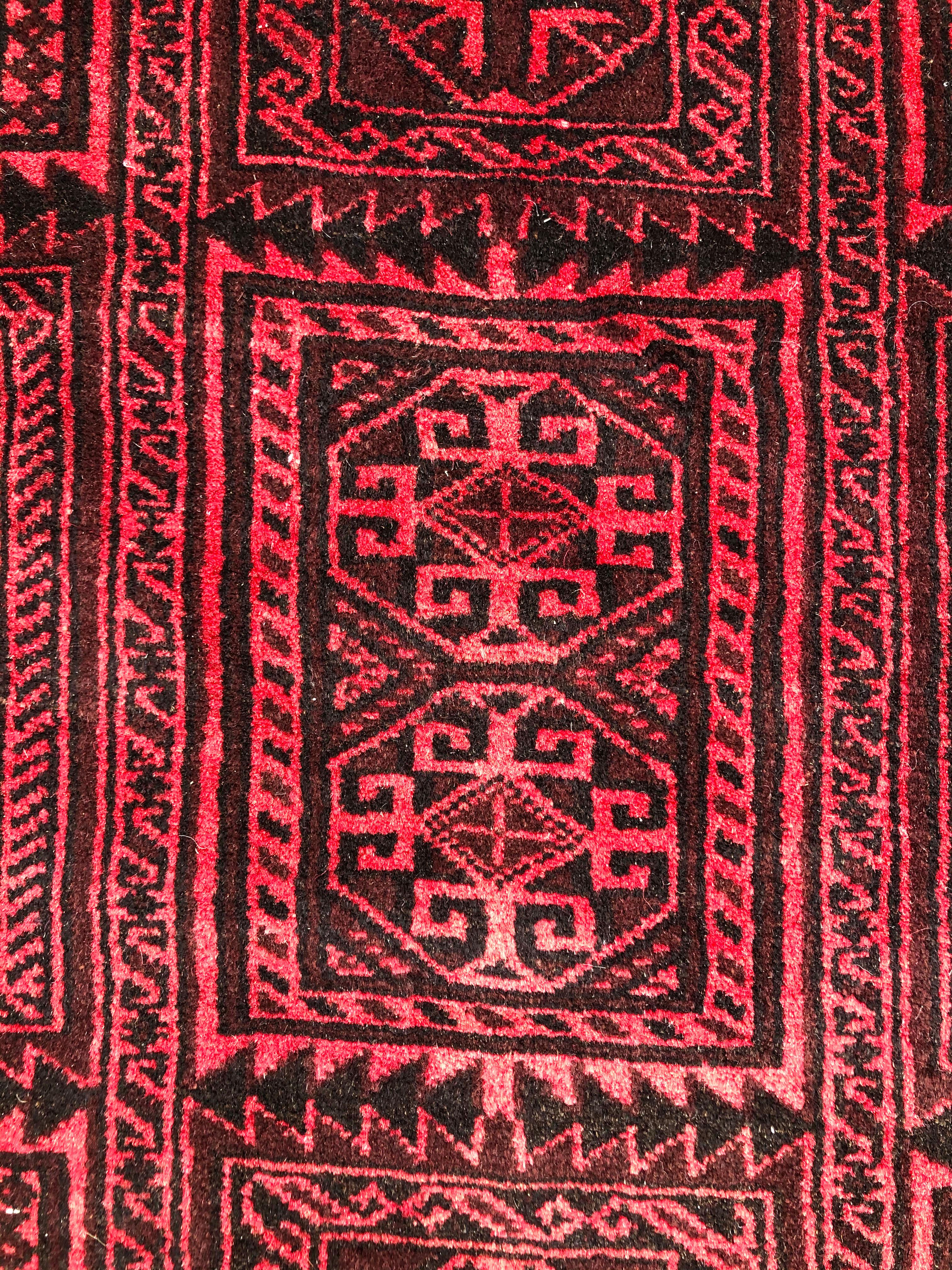 This authentic Persian Baluchi rug has wool pile and foundation which are hand knotted by the nomads of Baluchi. The age of this rug is almost 50 years old. The base and border color is red. The size of this rug is 4 feet 3 inches wide by 7 feet