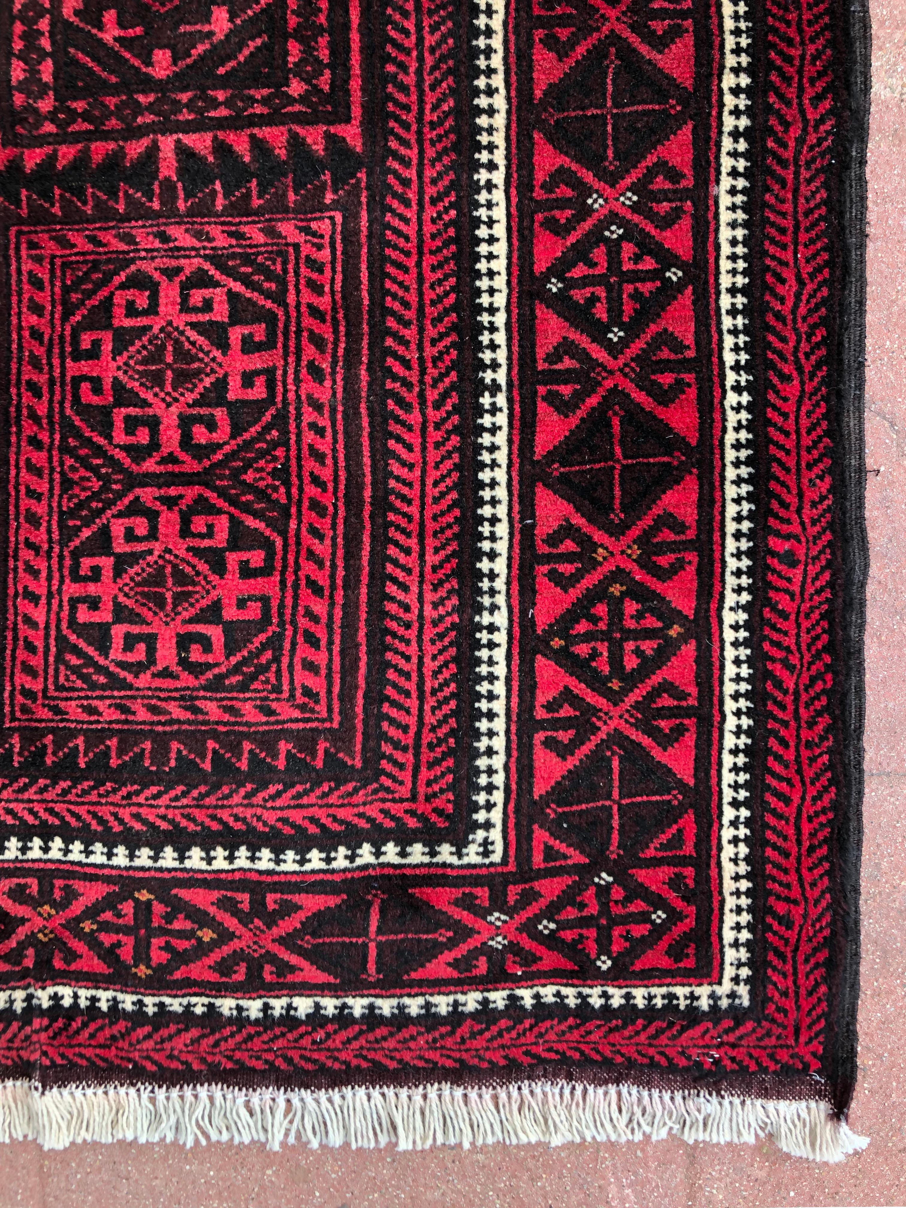 Noué à la main Tapis rouge Baluchi vintage:: Perse:: noué à la main:: avec panneaux tribaux:: vers 1960 en vente