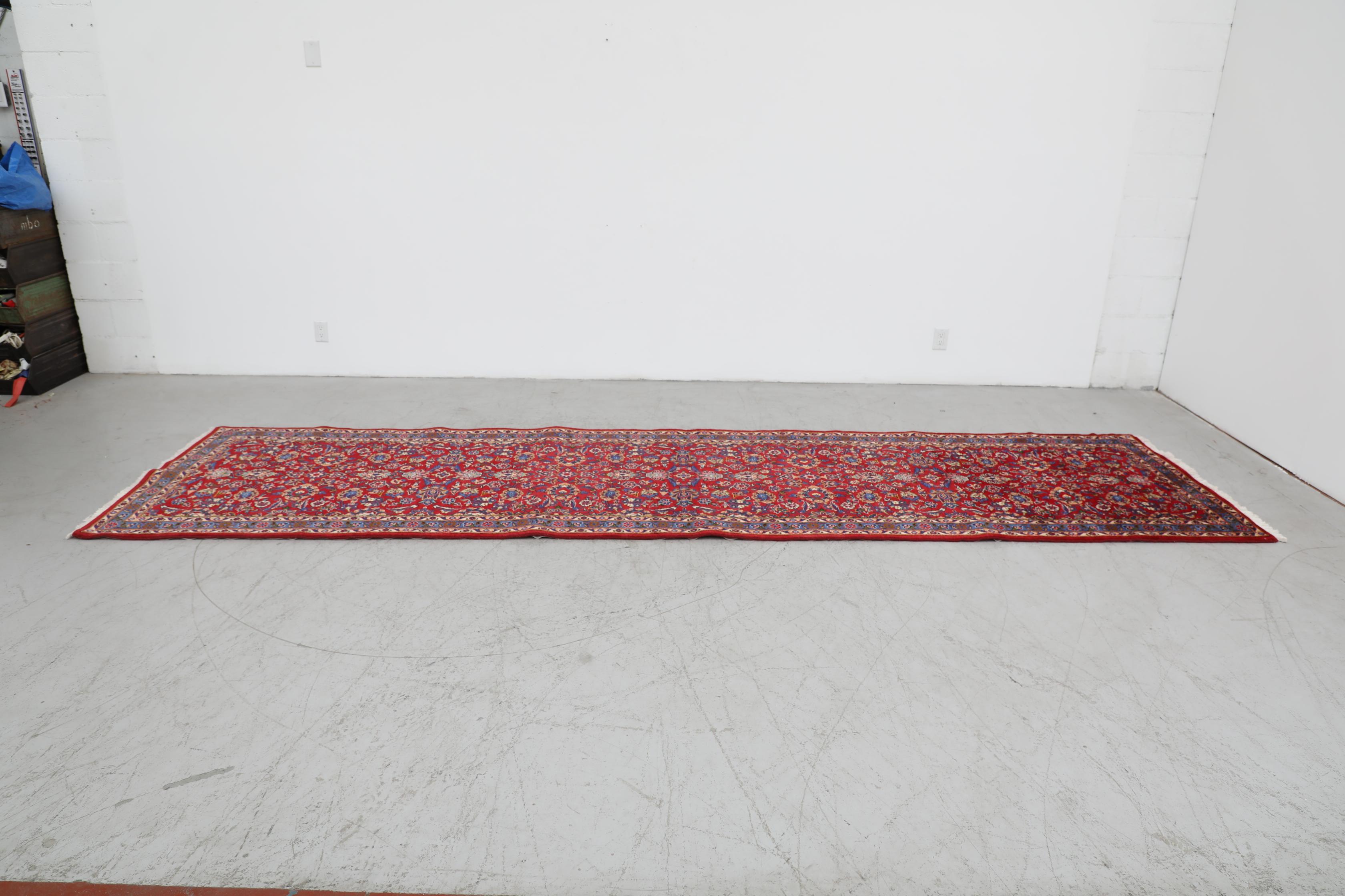 Splendido runner in lana tradizionale persiano, annodato a mano, lungo 14 piedi. Bellissimo disegno floreale ornato in rosso e blu. In condizioni originali, con un'usura visibile che corrisponde all'età e all'uso.