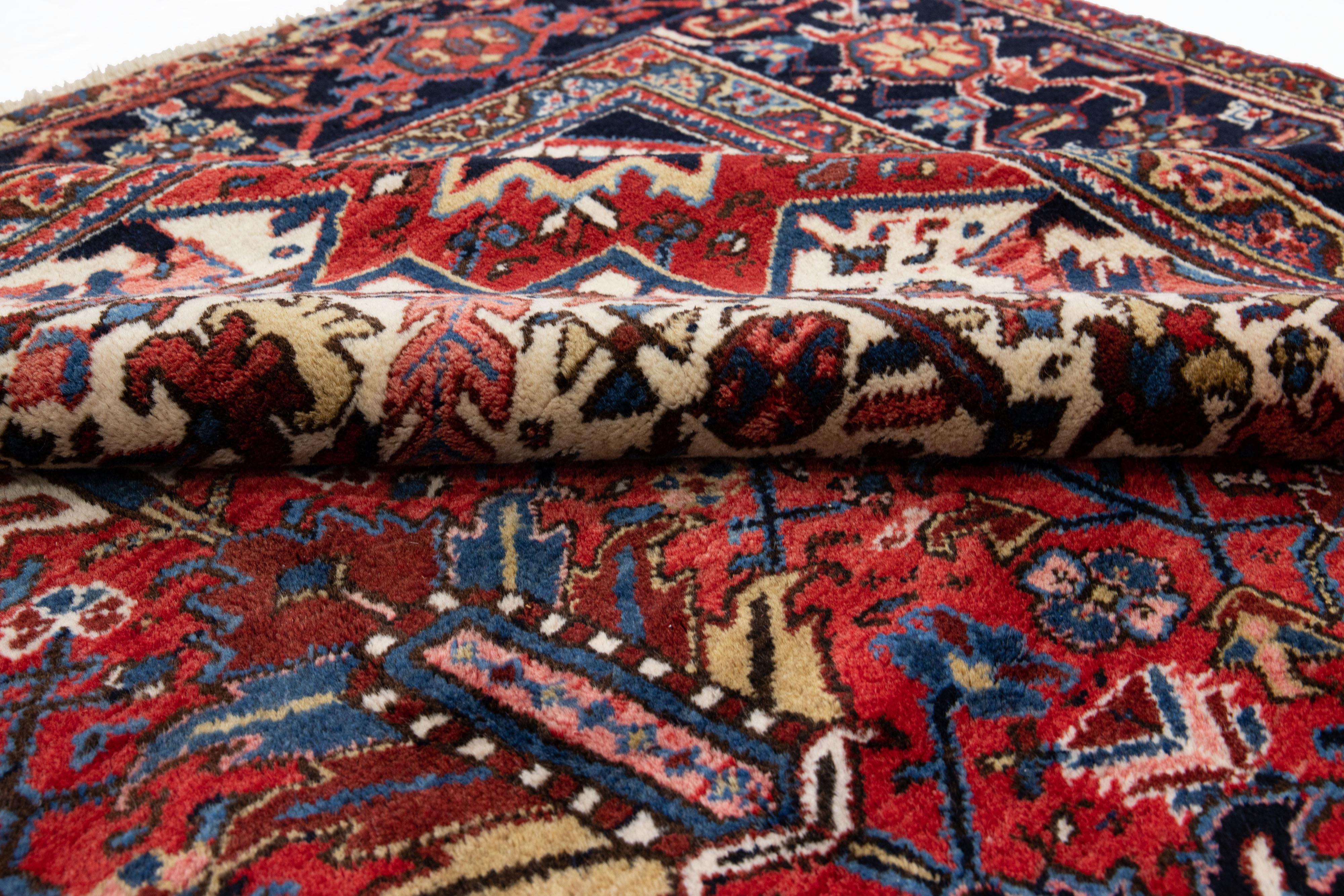 Magnifique tapis vintage Heriz en laine nouée à la main avec un champ rouge. Ce tapis persan a des accents multicolores qui présentent un magnifique motif géométrique floral en médaillon sur toute la surface.

Ce tapis mesure : 9'3