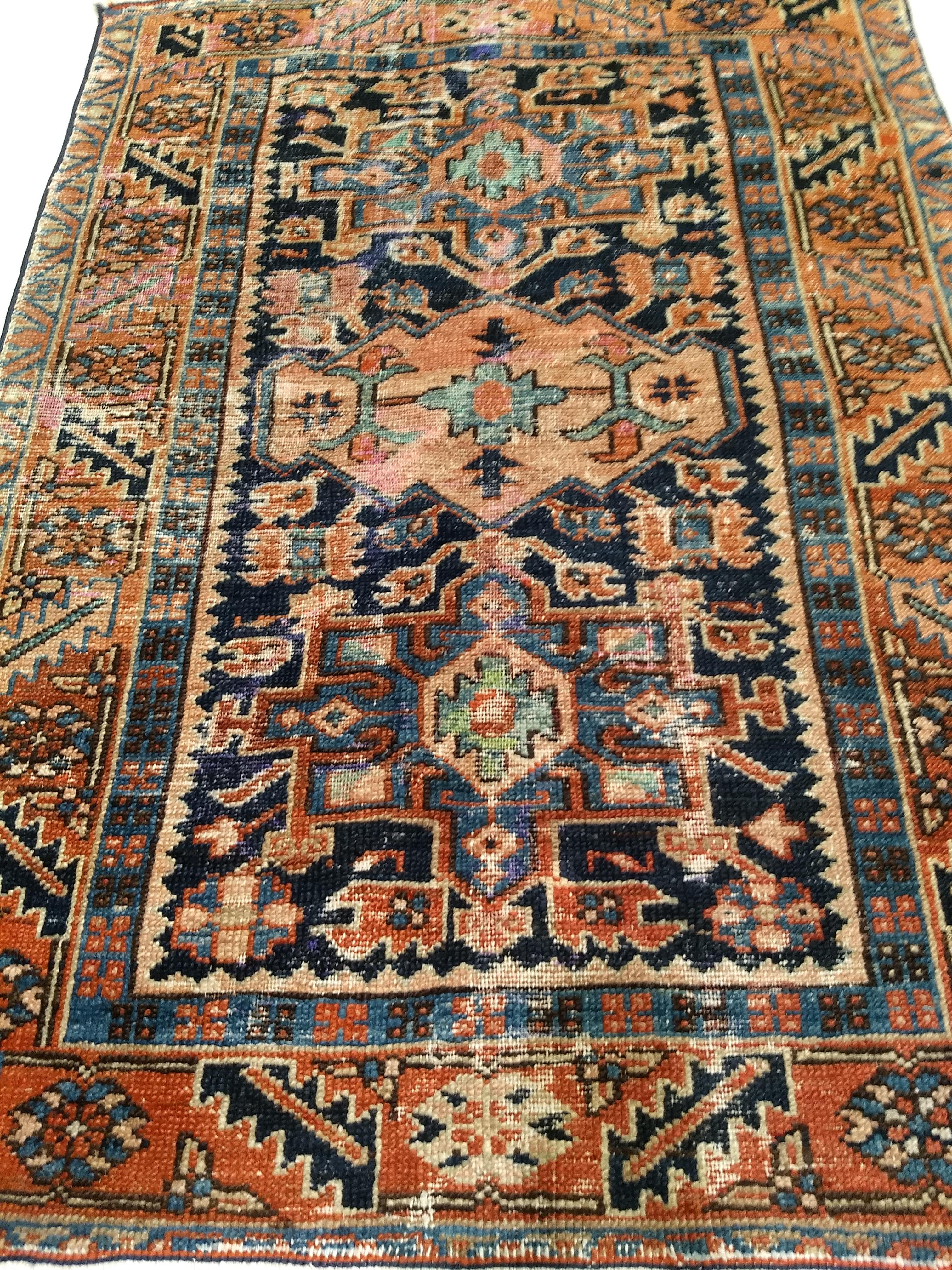 A beautiful handwoven Persian Karajeh area rug from the 1st quarter of the 1900s.  The rug has a “distressed look” with a traditional Karajeh design of 3 medallions set in a navy blue color field with the medallions in “abrash blue” and pink colors.