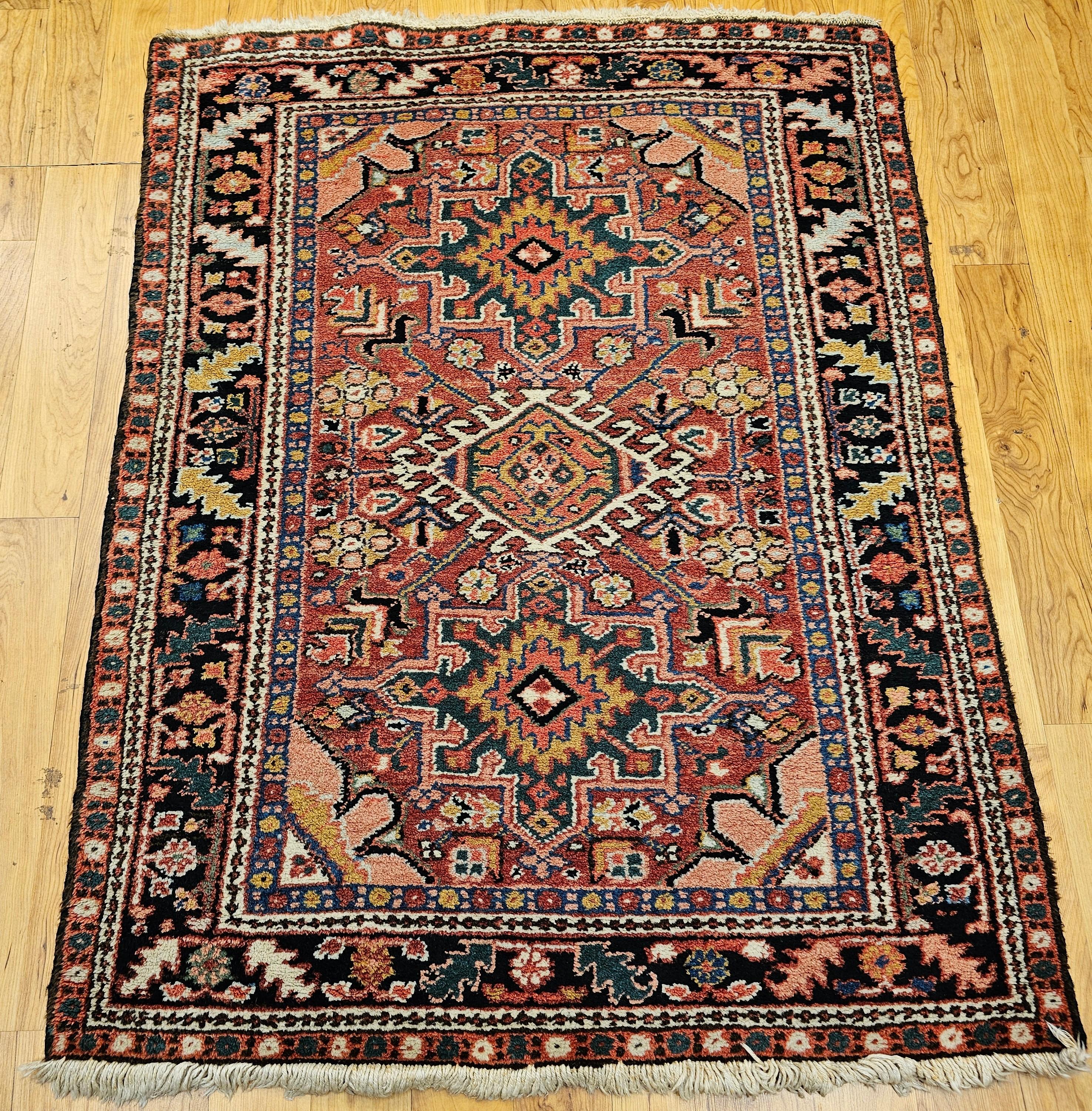 Ce tapis persan traditionnel Heriz Karajeh du nord-ouest de la Perse présente la disposition emblématique à trois médaillons caractéristique de ce style de tissage villageois historique. Tissé avec un riche champ rouge, le tapis présente des motifs