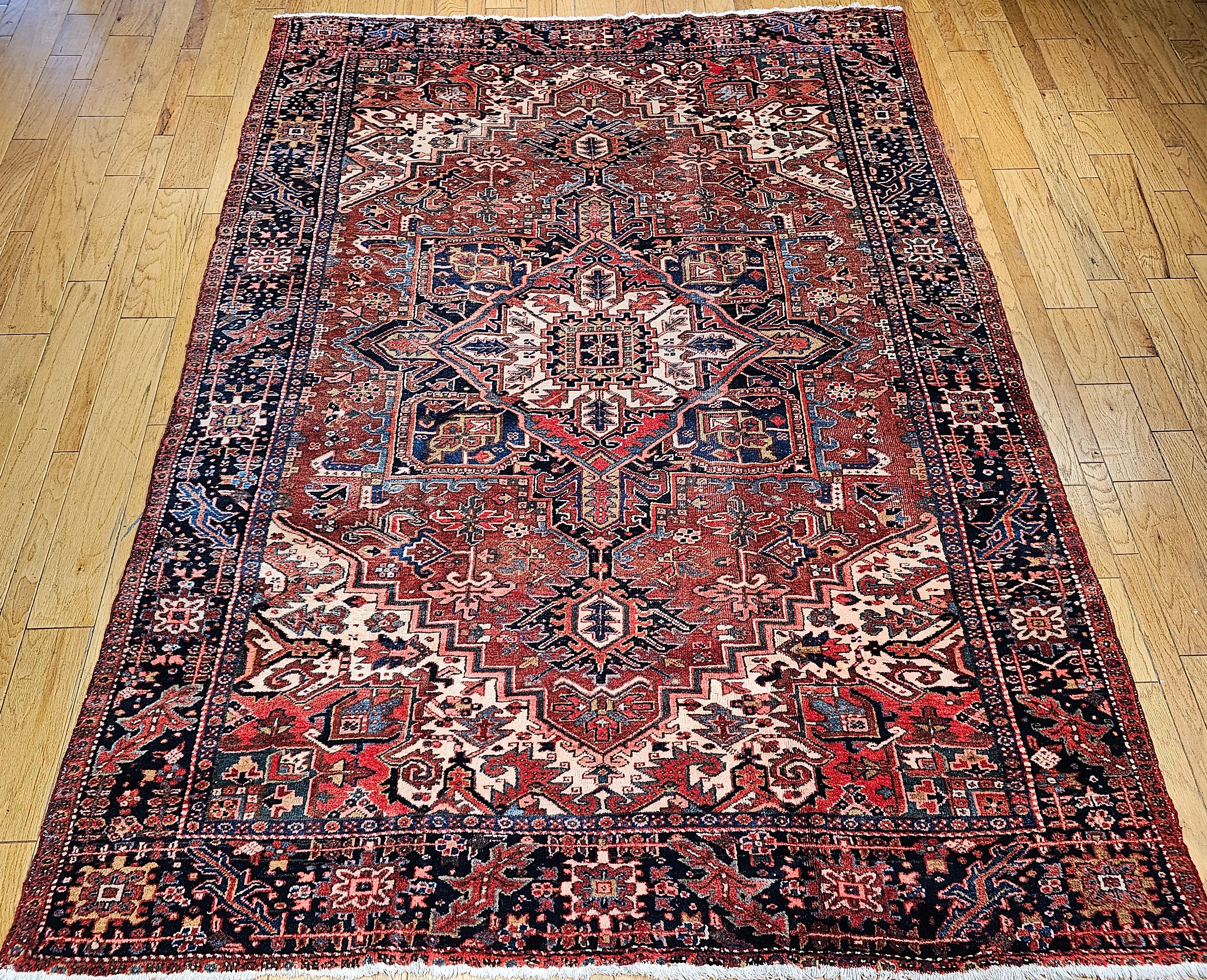 A beautiful Heriz room size rug from the village of Karajah in the Azerbaijan region of NW Persia circa the early 1900s It has a rich brick-red field color and a center medallion in ivory, blue and yellow which makes the medallion stand out. The