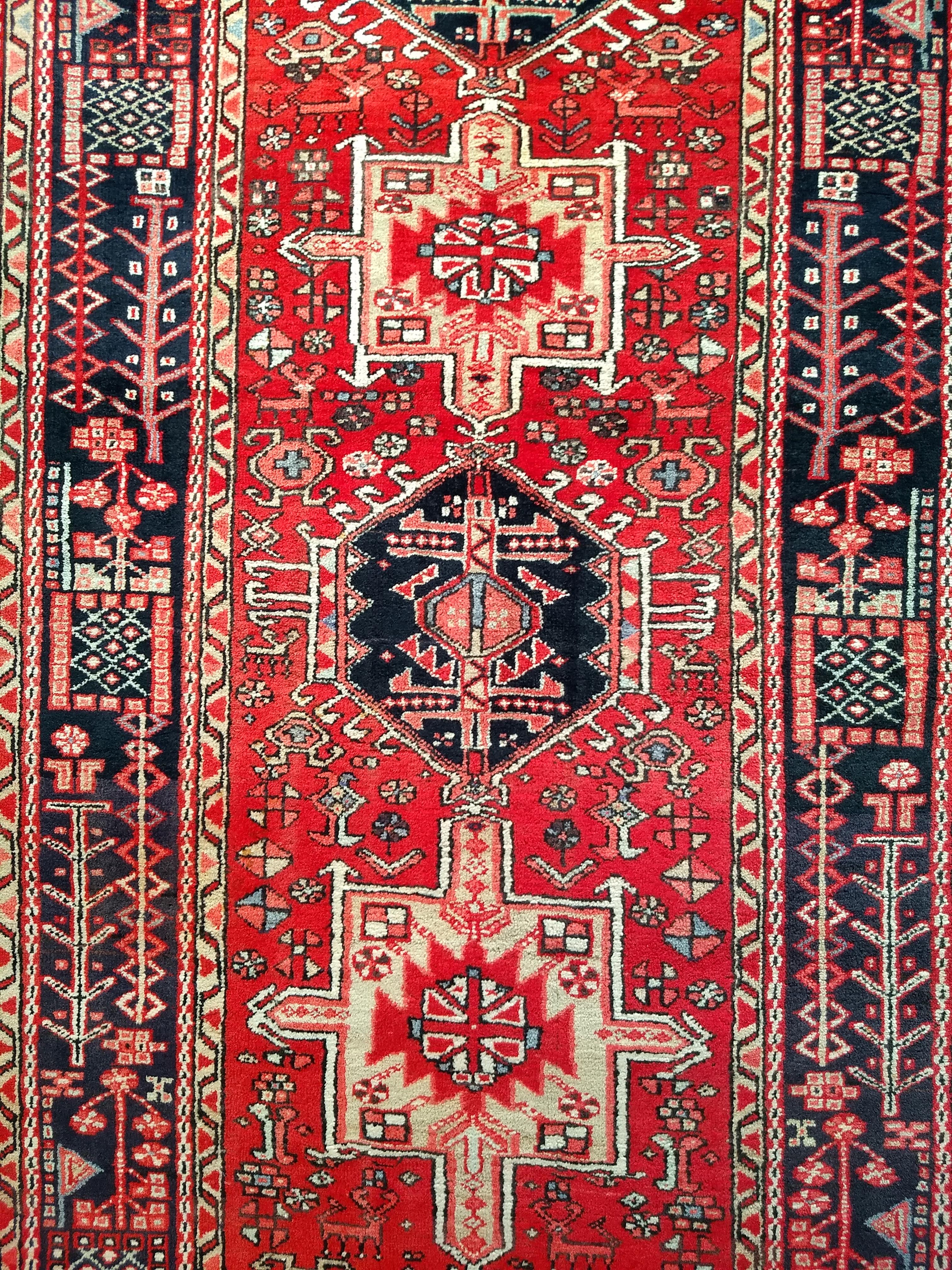 Un remarquable et généreux chemin de table persan Heriz Karajeh, tissé à la main au début du 20e siècle dans la province d'Azerbaïdjan, dans le nord-ouest de la Perse. Cette pièce illustre l'esthétique tribale emblématique de la région d'Heriz, avec