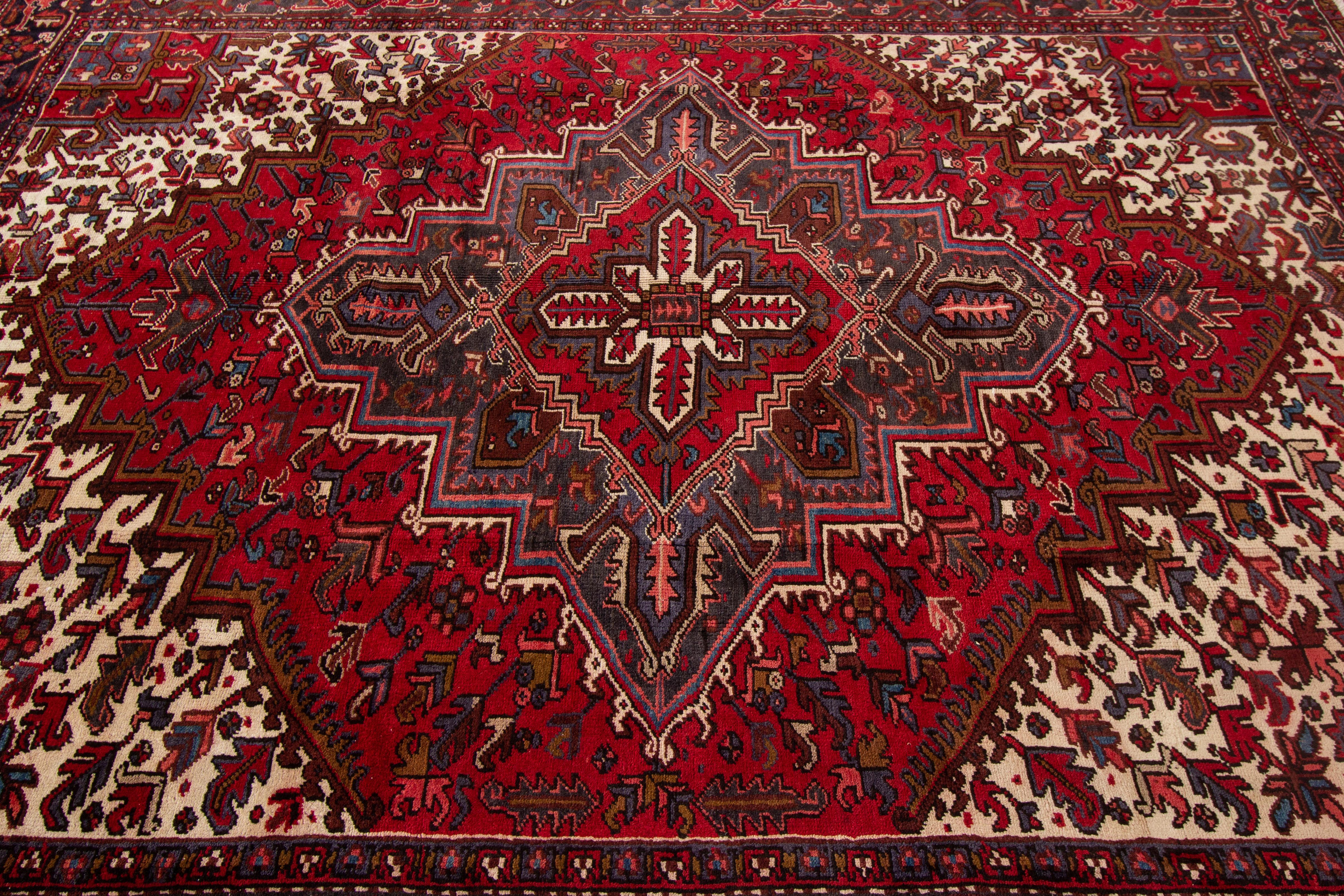A hand-knotted vintage Heriz rug with a medallion design. This rug measures: 7'11