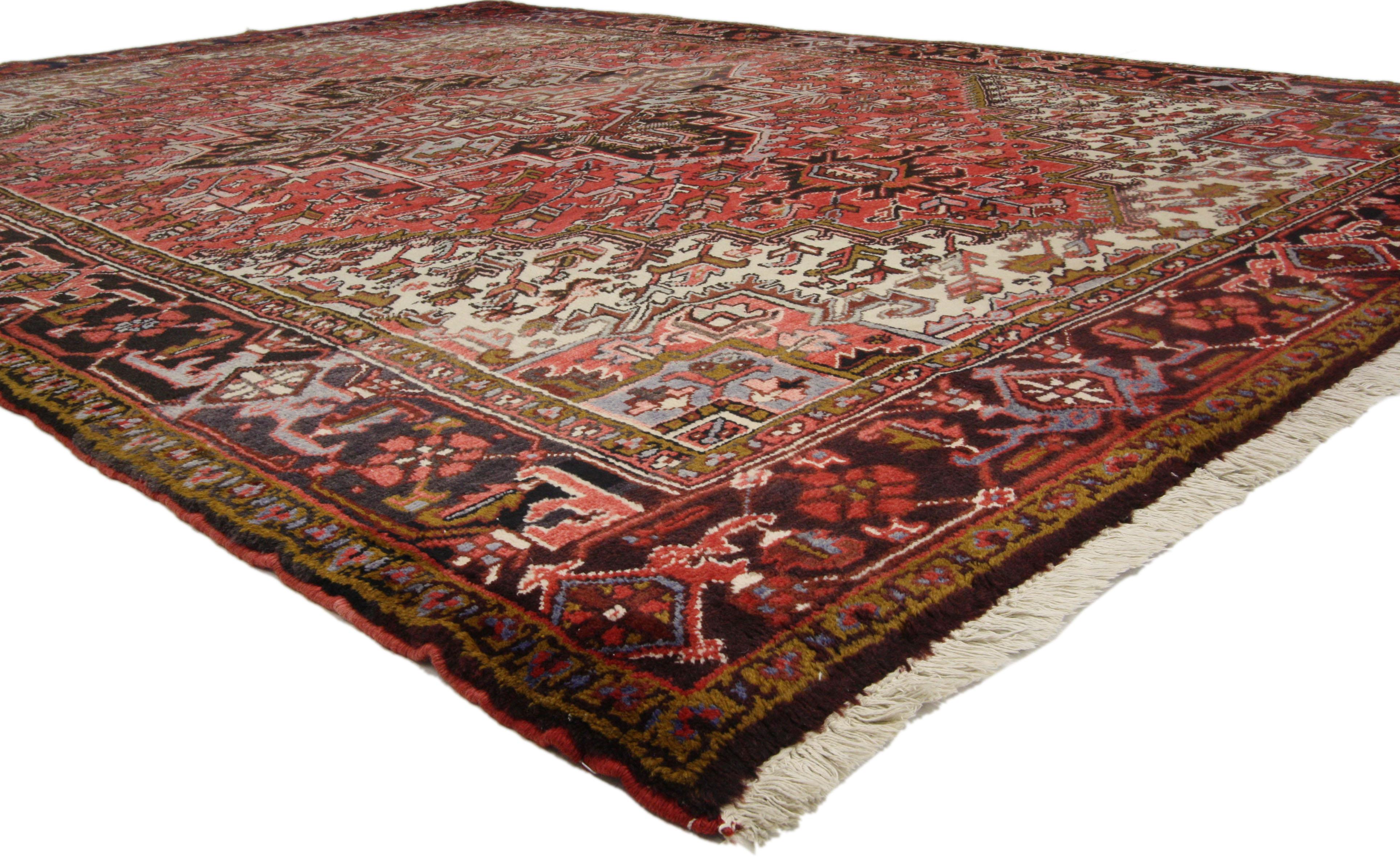 Impeccably woven from hand-knotted wool, this vintage Persian Heriz rug showcases Mid-Century Modern style and a beautiful tribal design highlighting the classical elements of Persian culture. This vintage Heriz rug has many layers that perform well