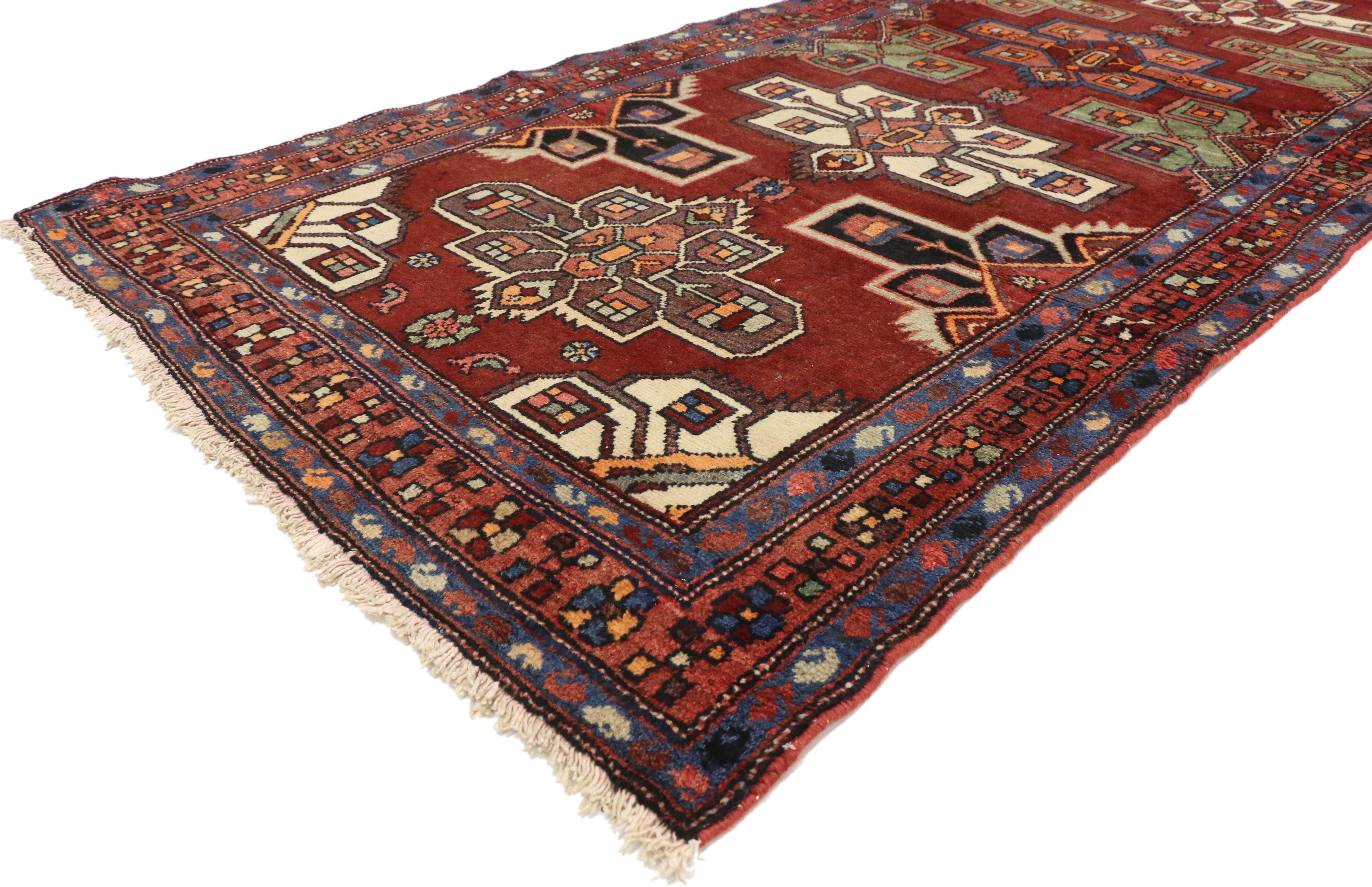 76358, Vintage Persian Heriz Runner, Mid-Century Modern hallway runner. This hand knotted wool vintage Persian Heriz runner features five stepped amulet medallions with stepped ziggurats reaching towards the centre floating in an abrashed red field.