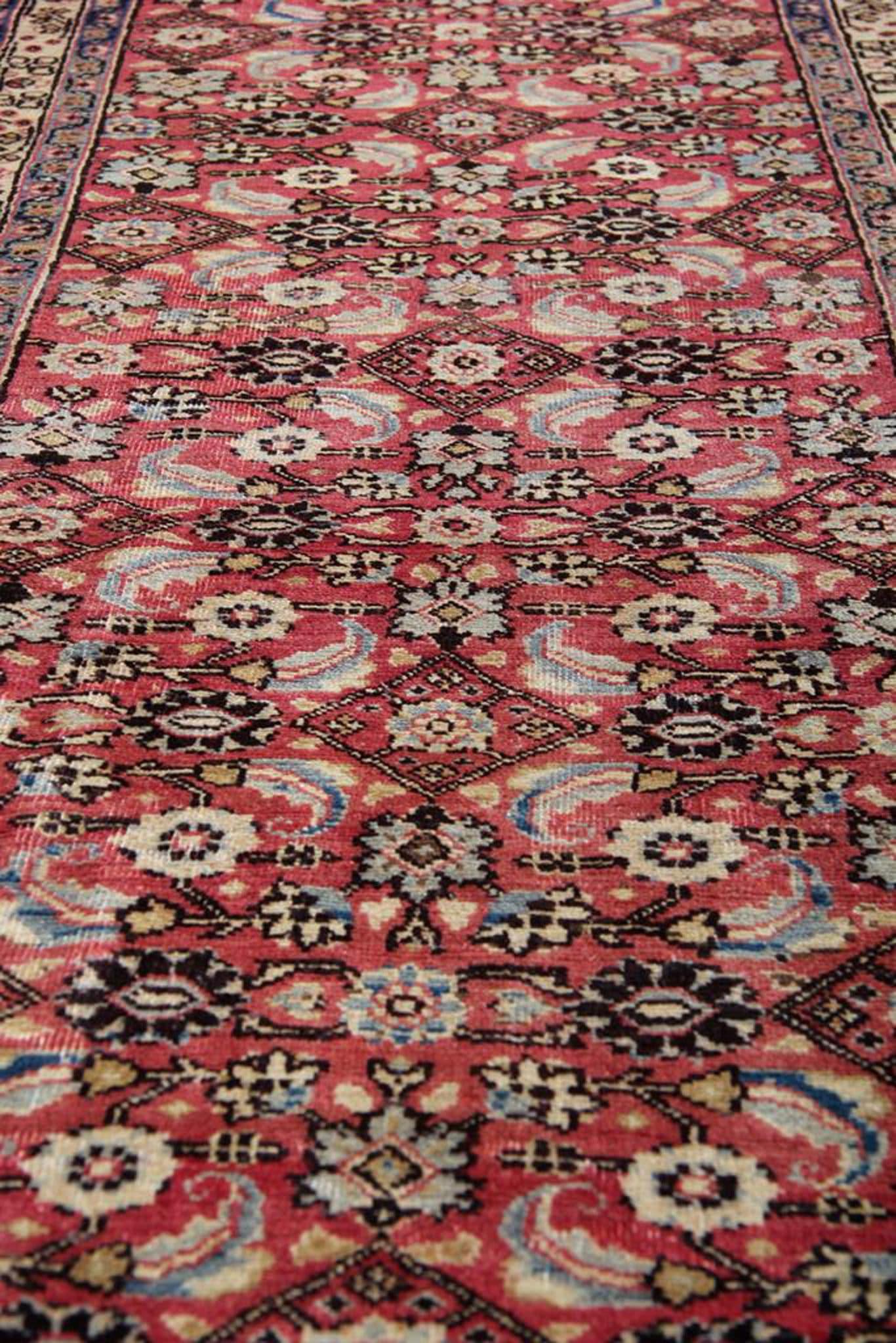 This rug boasts a hand-knotted weave, a testament to the meticulous attention to detail and craftsmanship invested in its creation. Despite its vintage status, this rug remains in excellent condition, a testament to its durability and the quality of