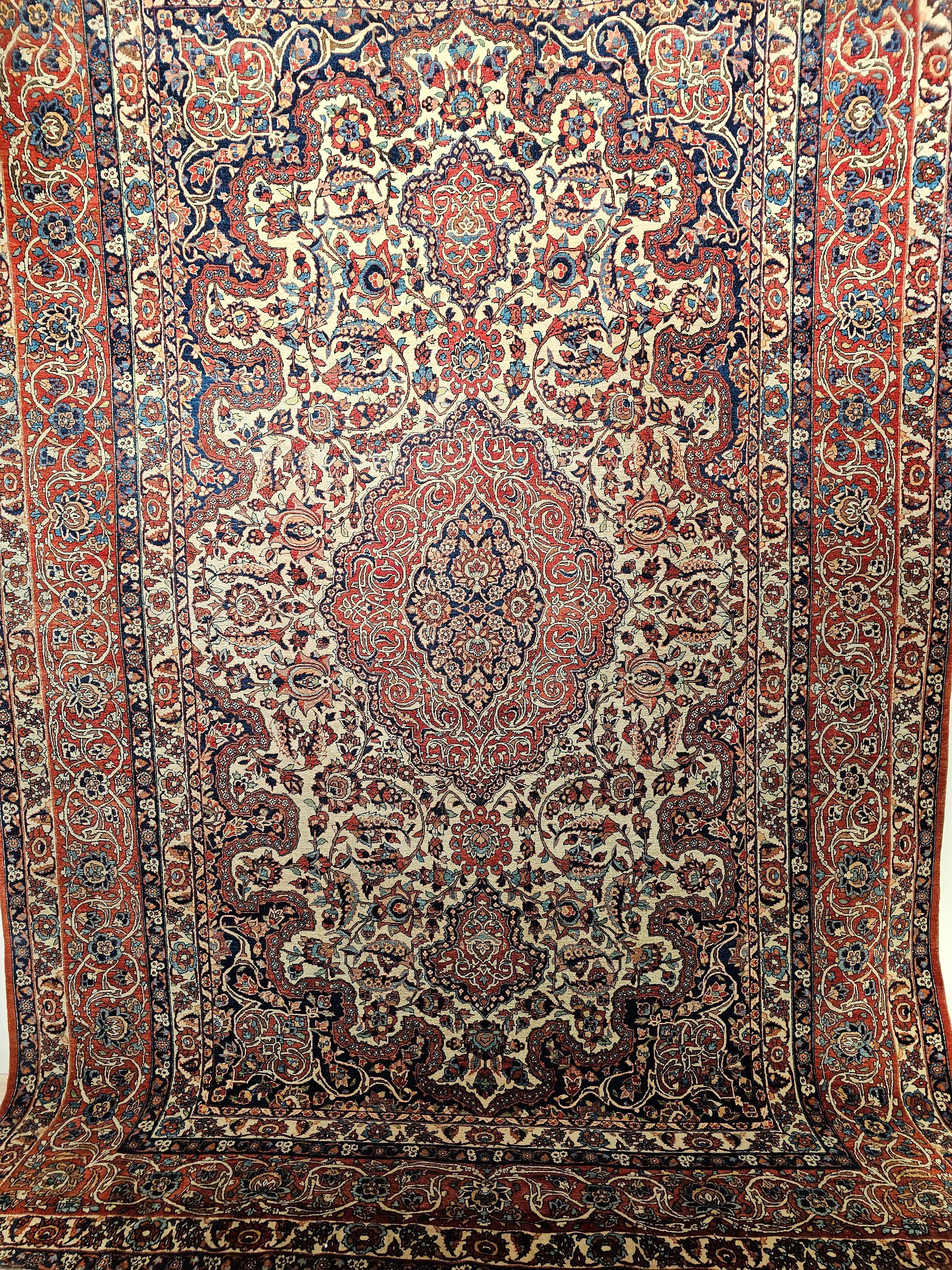Vintage  room-size Persian Isfahan rug from the 1st quarter of the 1900s.  The beautiful hand-knotted  rug has a very fine weave and very high knot count.  The pattern is the classic Shah Abbas large format “Leaf and Sickle” design with scrolling