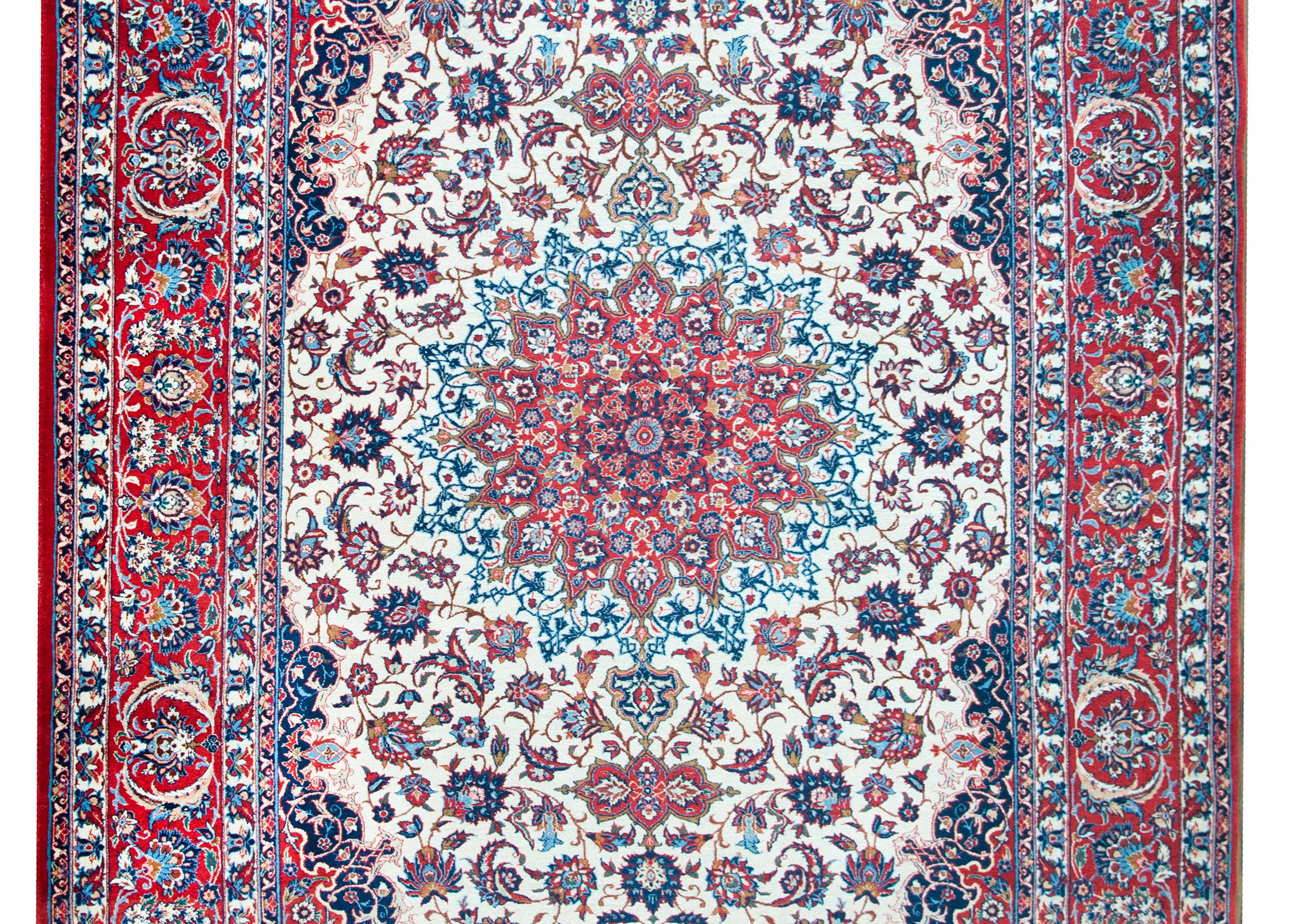 A mesmerizing mid-20th century Persian Isfahan rug with the most elaborate central floral medallion reminiscent of a stained glass window, living amidst a field of intensely woven flowers and scrolling vines, surrounded by a wide complex border