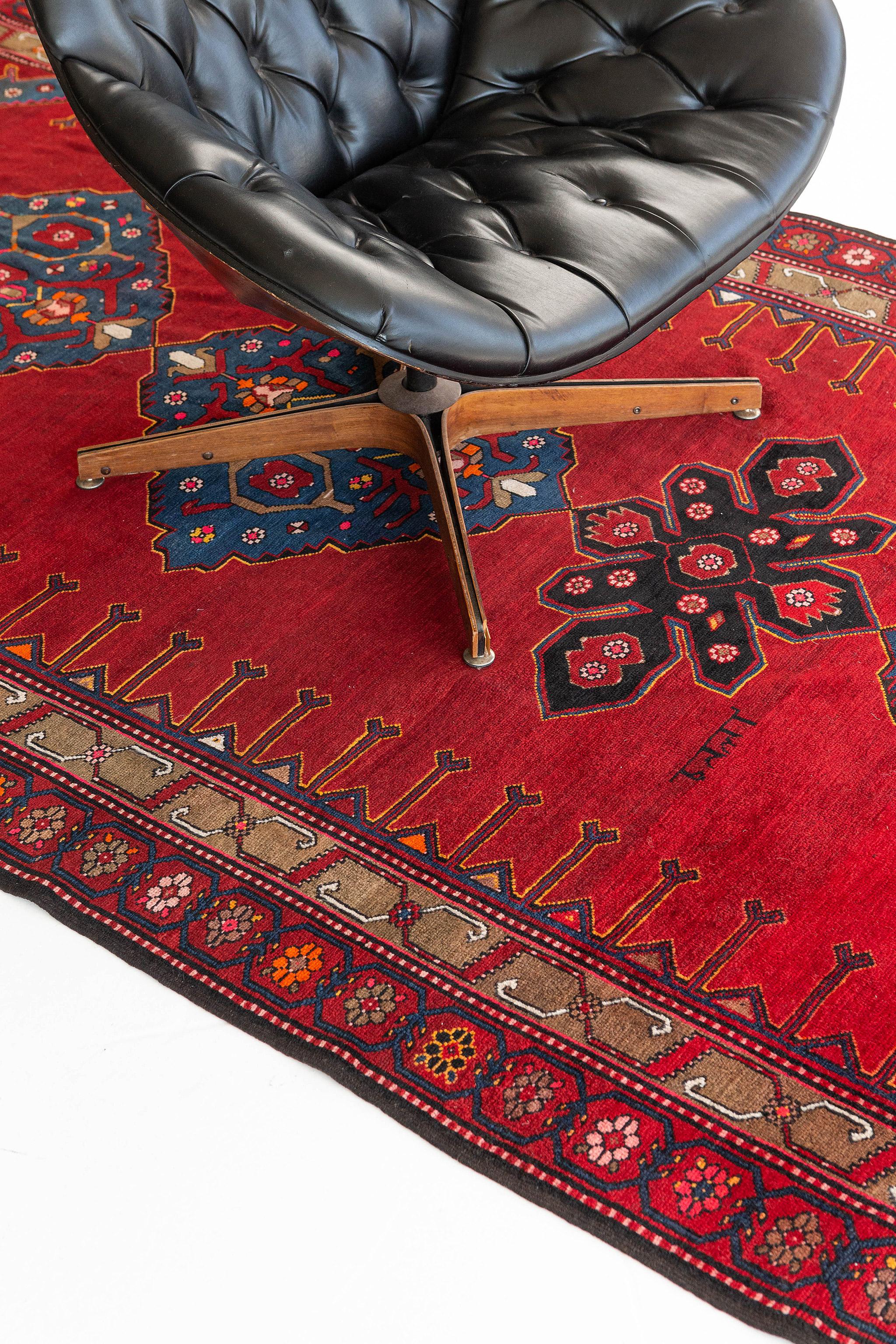 A luxurious Karabagh runner features aligned midnight blue medallions and a modest spandrel in a vibrant red field. The florets that surround the design make it more wonderful and eccentric. A masterpiece that would be lovely to be added to your
