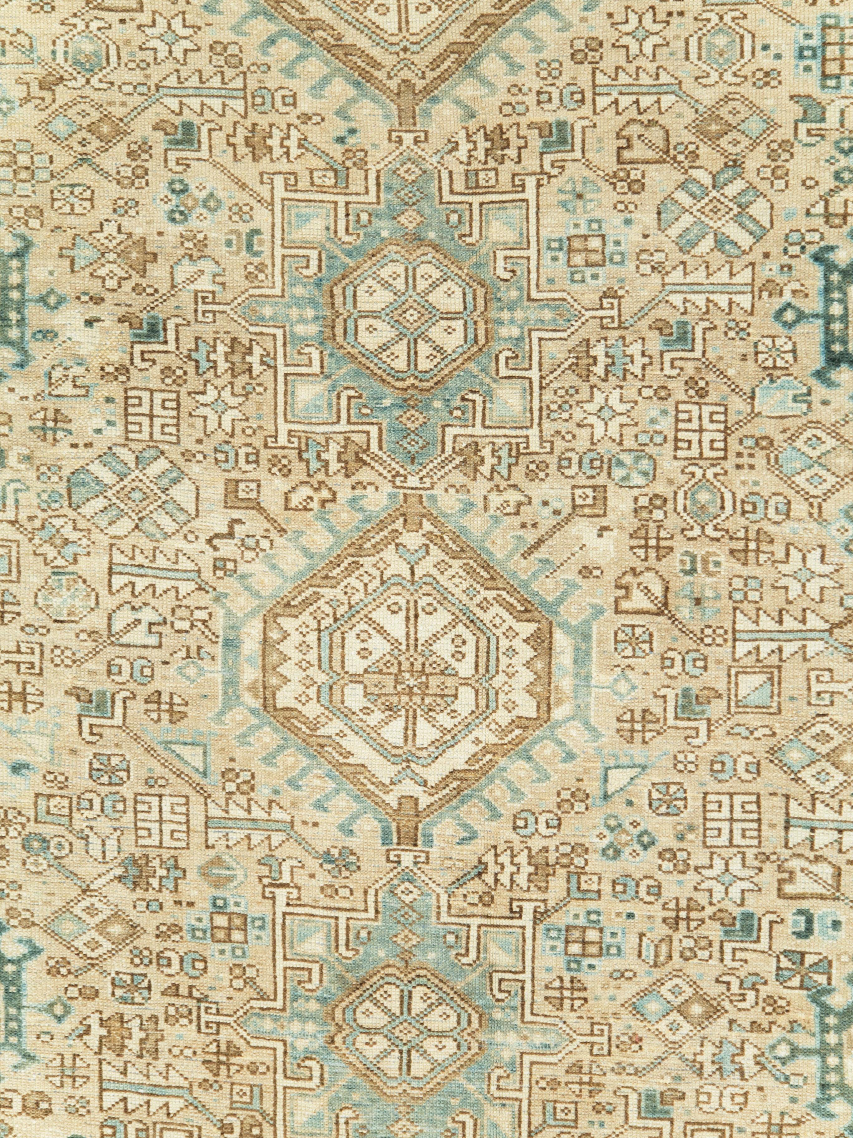 A vintage Persian Karajeh carpet from the mid-20th century. This sand toned NW Persian village carpet from the Persian Heriz district show three columns of characteristic Karajeh octogrammes alternating with hooked hexagons, against a close