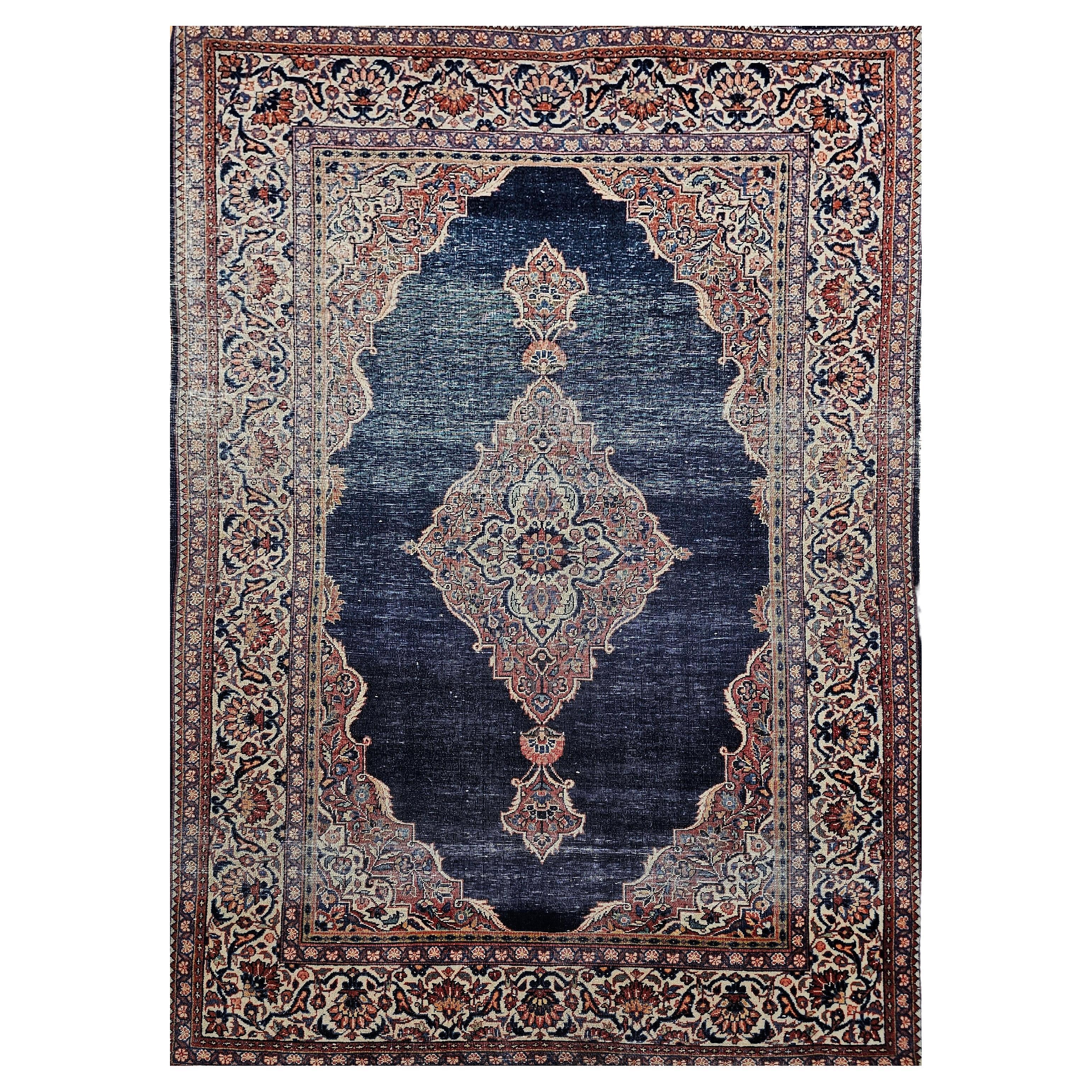 Alfombra persa Kashan de principios del siglo XX en azul marino, marfil, rojo, verde y tostado en venta