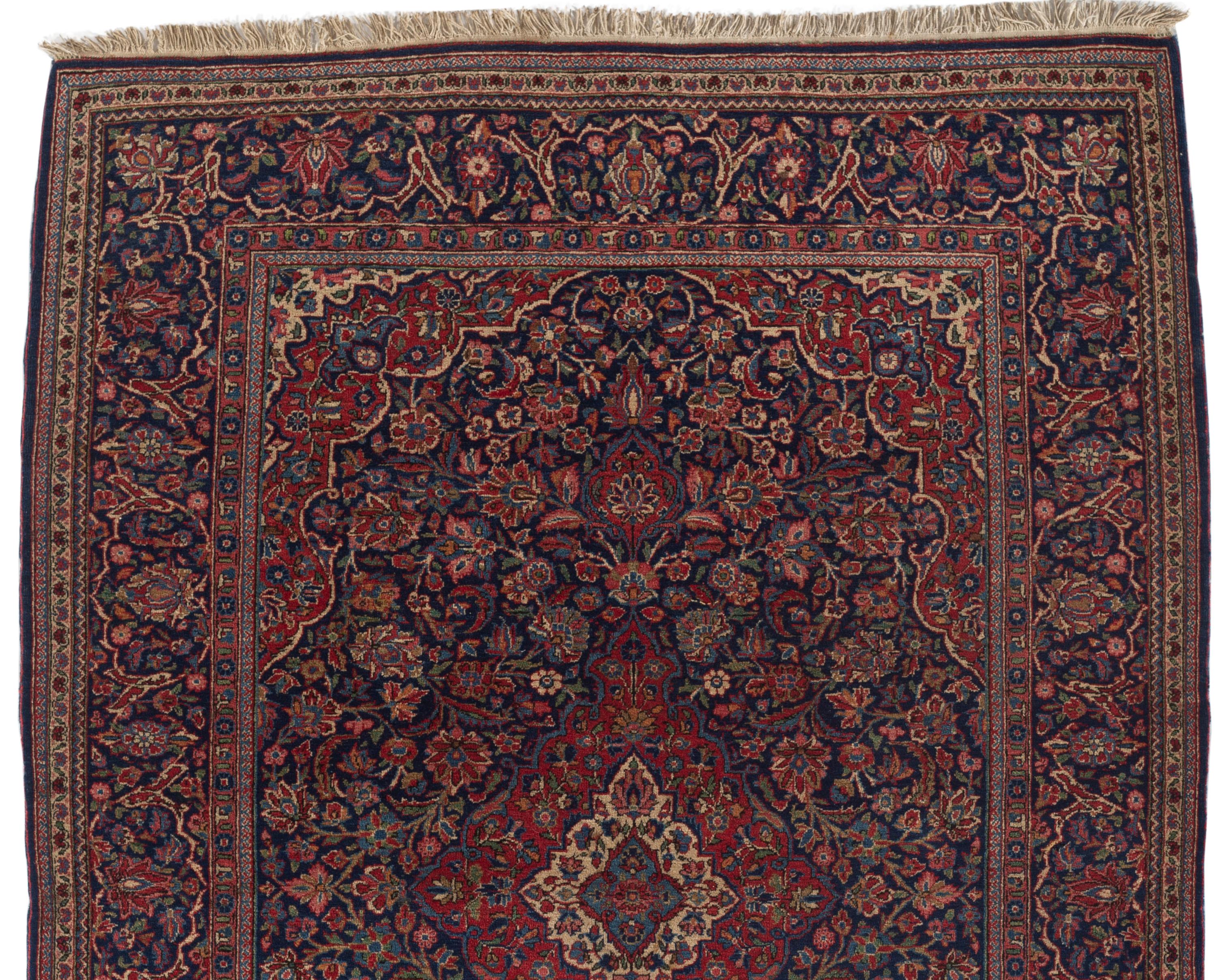 Vintage Persian Kashan, circa 1920. This Persian handwoven Kashan rug has a glorious central deep blue field filled with floral elements surrounding a central medallion. The main border compliments this picture to perfection. Size: 4'3 x 6'9.