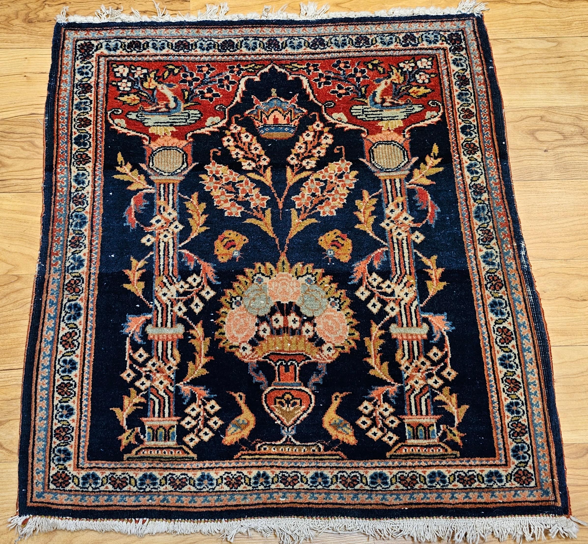 Tapis vintage à motifs picturaux de Kashan avec un motif de vase et une représentation de la couronne royale persane.  Le petit tapis pictural a un fond bleu marine avec des motifs en rouge, vert, ivoire et rose.  Il s'agit d'un merveilleux petit
