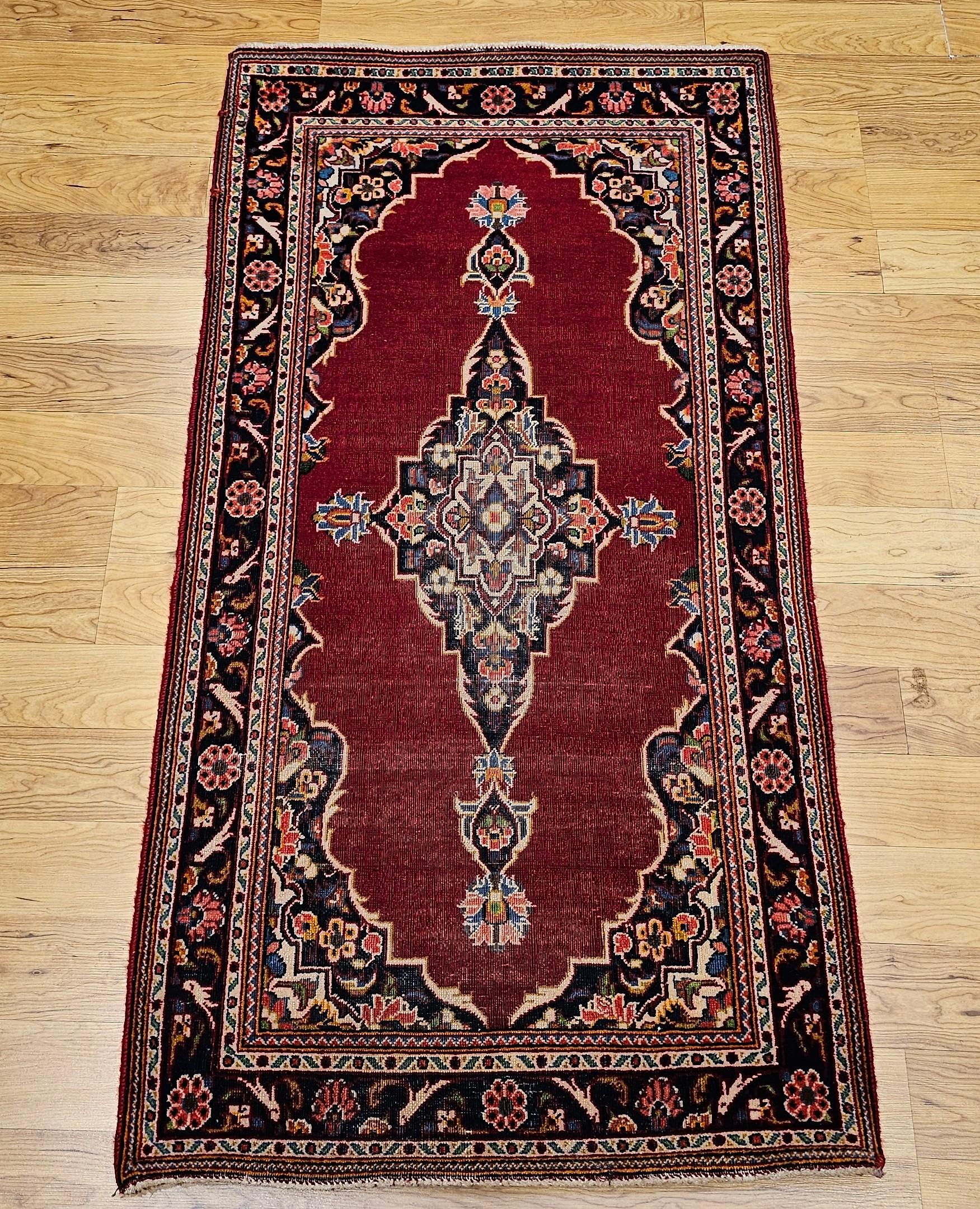 A timeless statement piece, this vintage Persian Kashan area rug from the mid-20th century features a refined floral medallion design that embodies the elegance of traditional Persian artistry. Set against a rich red field, the intricate central
