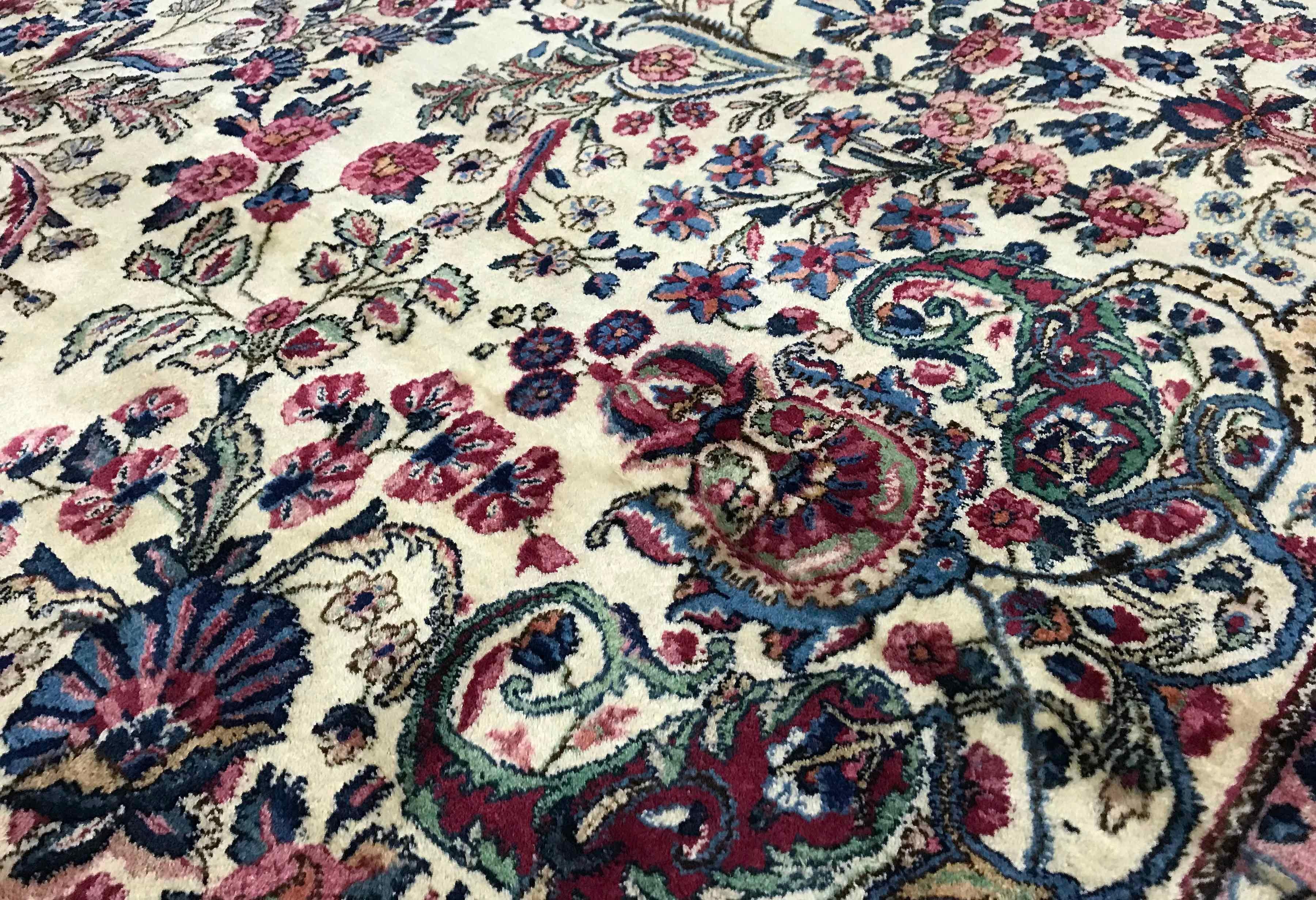 Vintage Persian Kerman Ivory / Blue, circa 1940. Ce tapis Kerman surdimensionné présente un aspect classique avec un champ ivoire doux rempli de motifs floraux et incorporant un motif central répétant le thème floral, entouré d'une bordure
